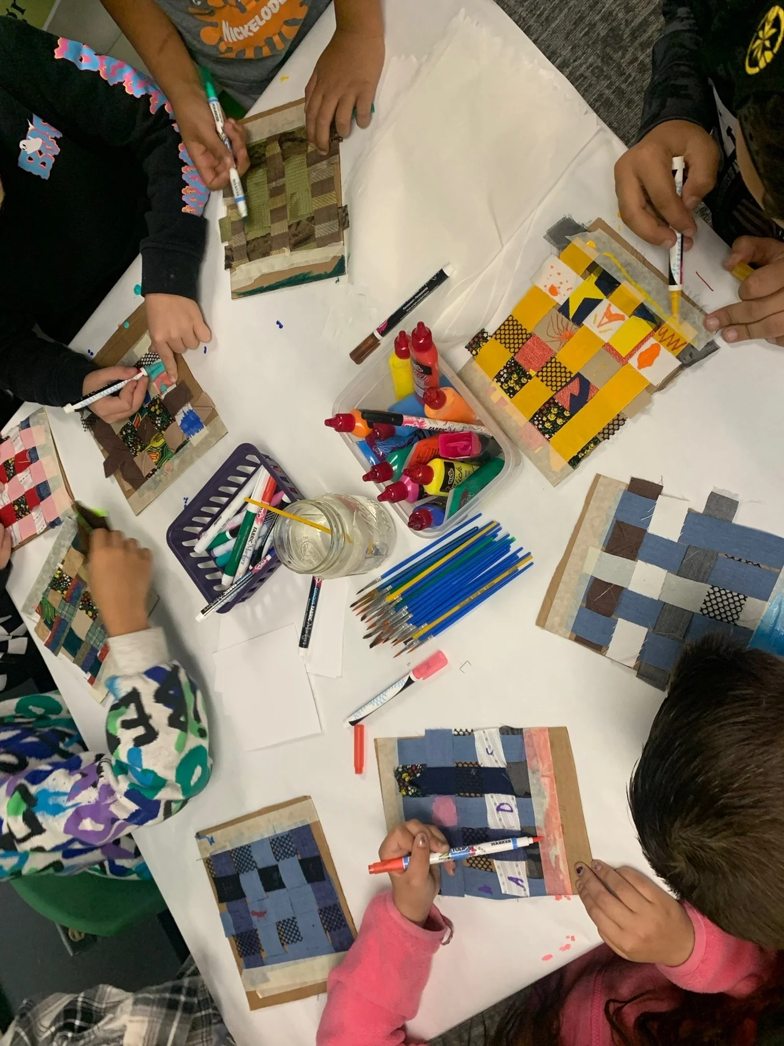 "Fabric Weaving & Fabric Paint Artwork" by 3rd grade artists (2023).