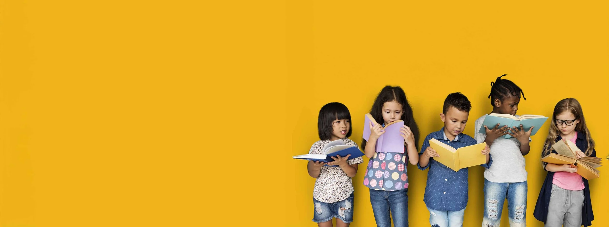Six diverse children standing against a yellow wall, reading open books.
