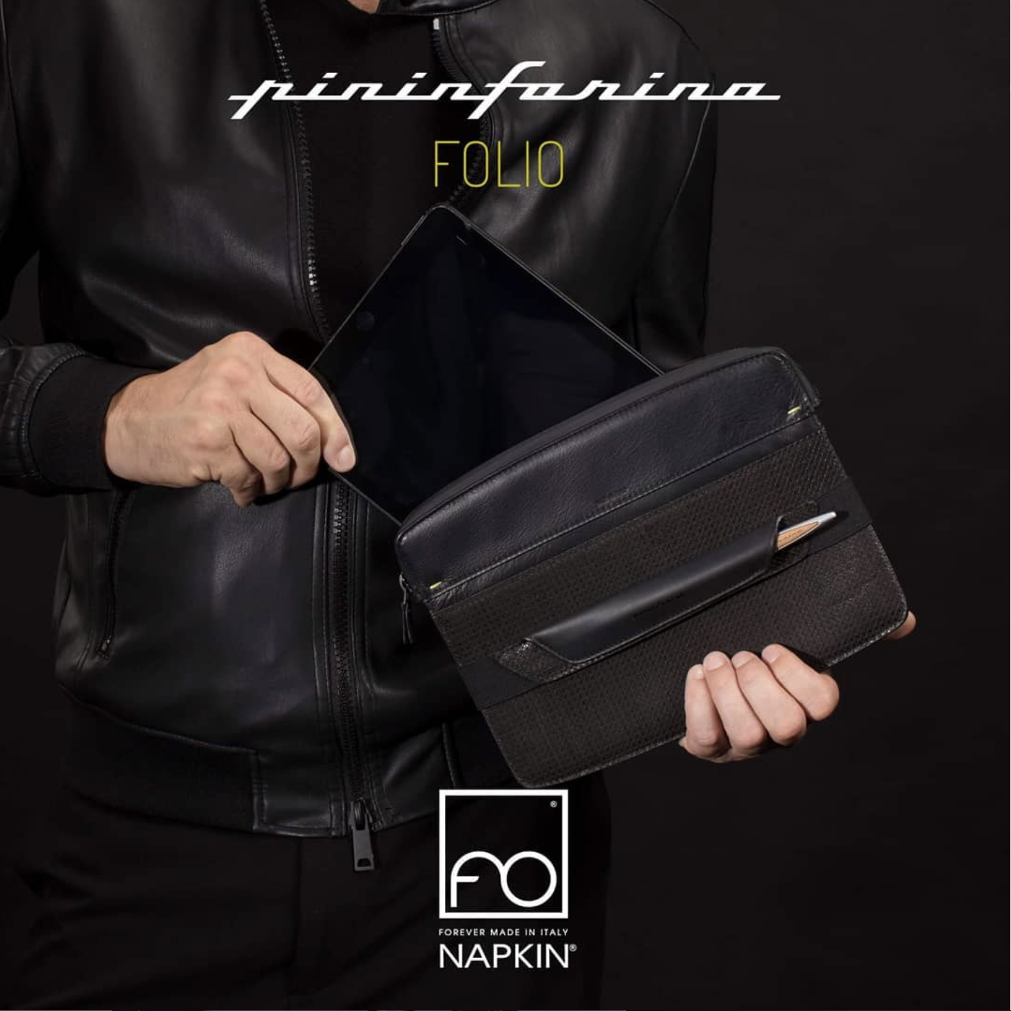 Persona che tiene in mano un tablet che viene riposto in una tracolla nera con dettagli in pelle. La persona indossa una giacca nera in pelle. pininfarina folio, campagna pubblicitaria, strategia social, borse e accessori, advertising.