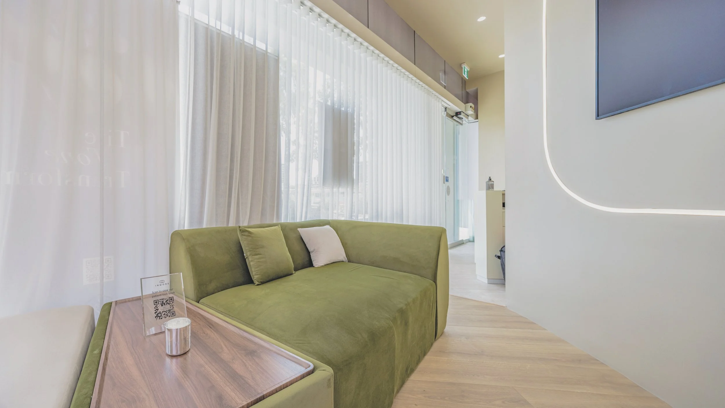 Sage green velvet sofa in the waiting lounge at Noa Skin Zetland — calm, considered interior for our Sydney inner south skin clinic