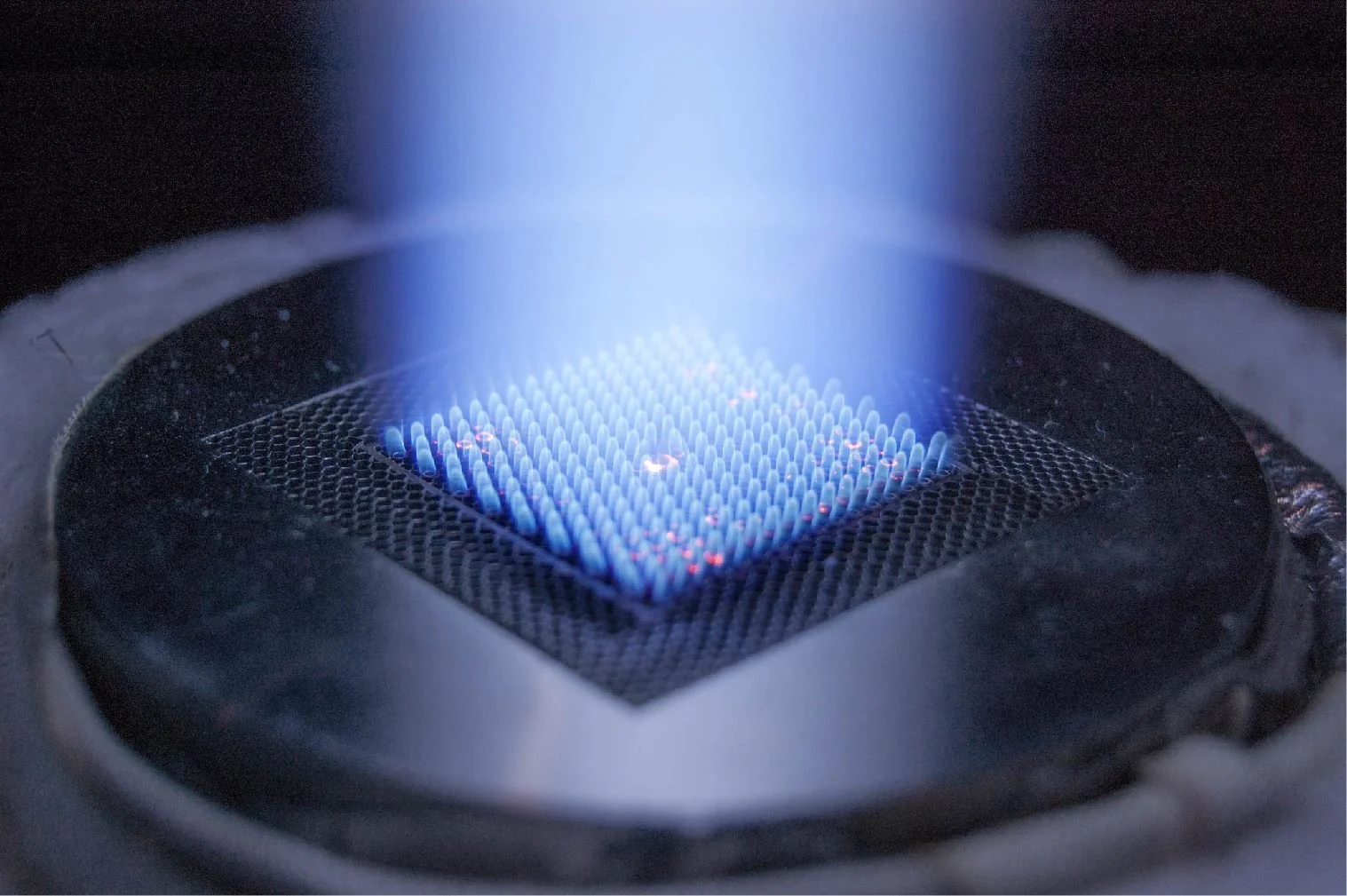 Close-up of a blue flame on a gas stove burner.