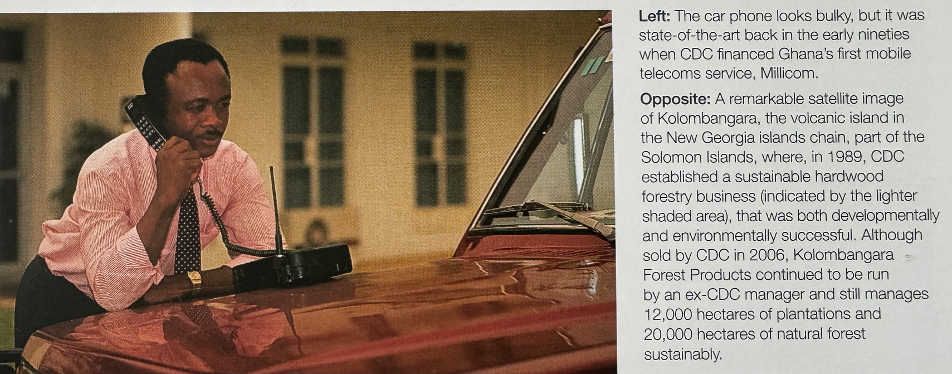 a man in a pick shirt using an early mobile phone from the 1990s. The man is leaning on the bonnet of a red car