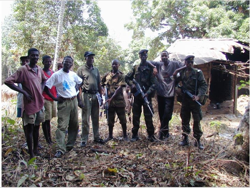 A group of men standing together some holding rifles to protect the group