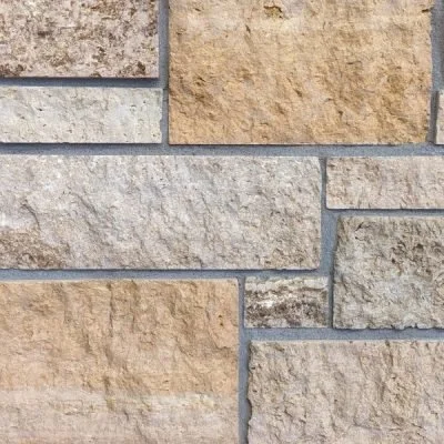 Close-up of a beige and gray brick wall.