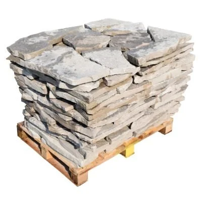 A stack of flat, irregularly shaped grey stone slabs on a wooden pallet.