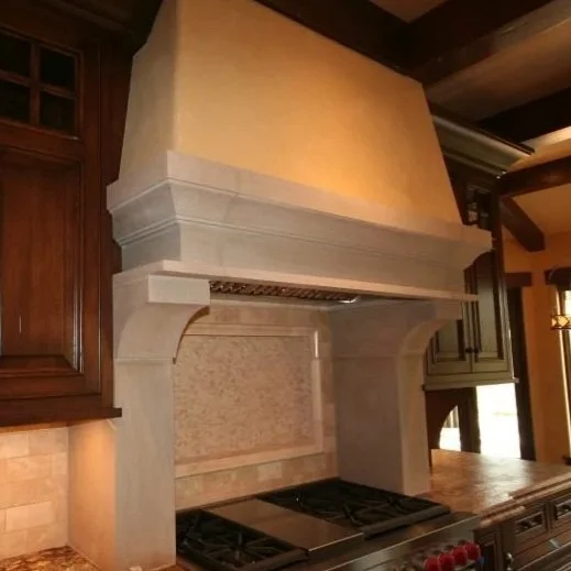 Kitchen with large beige range hood above a stove with black burners, surrounded by dark wooden cabinets.
