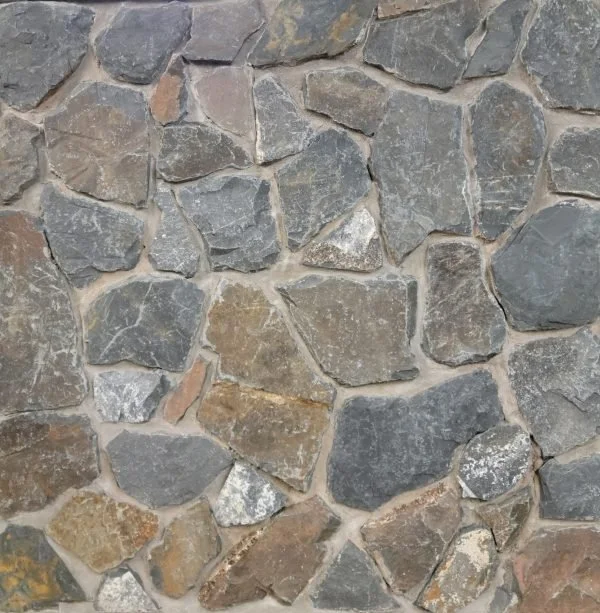 Close-up of a stone wall with irregularly shaped stones in gray, brown, and tan colors, fitted together with mortar.