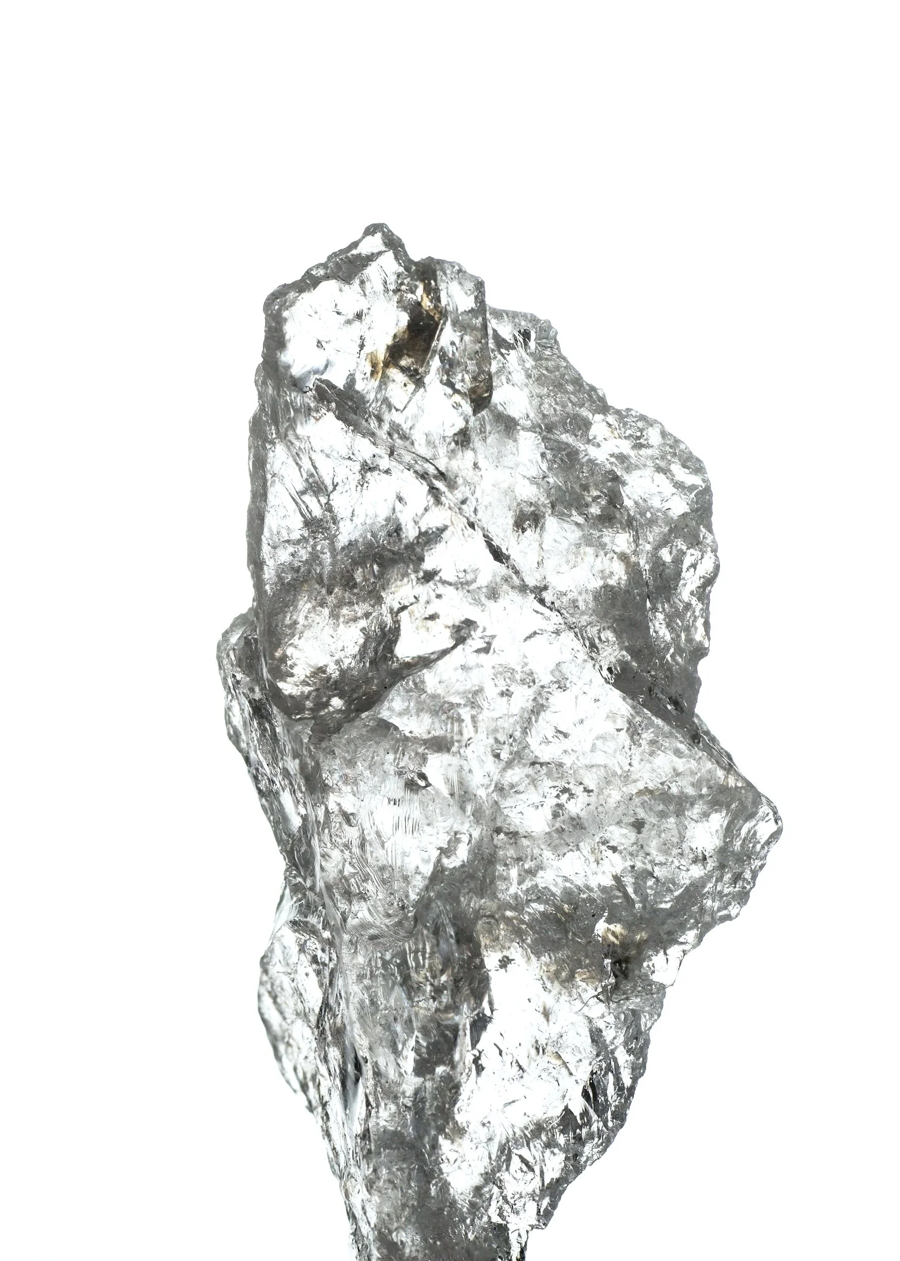 Close-up of a clear, irregularly shaped piece of ice with a rough texture, set against a white background.