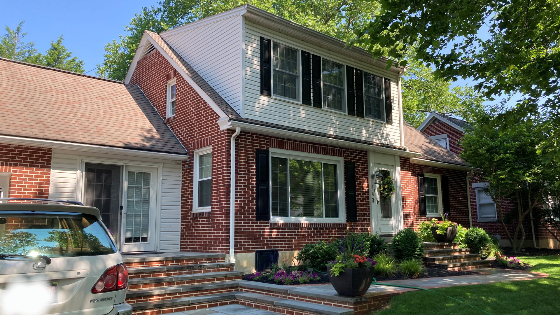 Traditional brick home with a seamless two-story addition and landscaped front entry.
