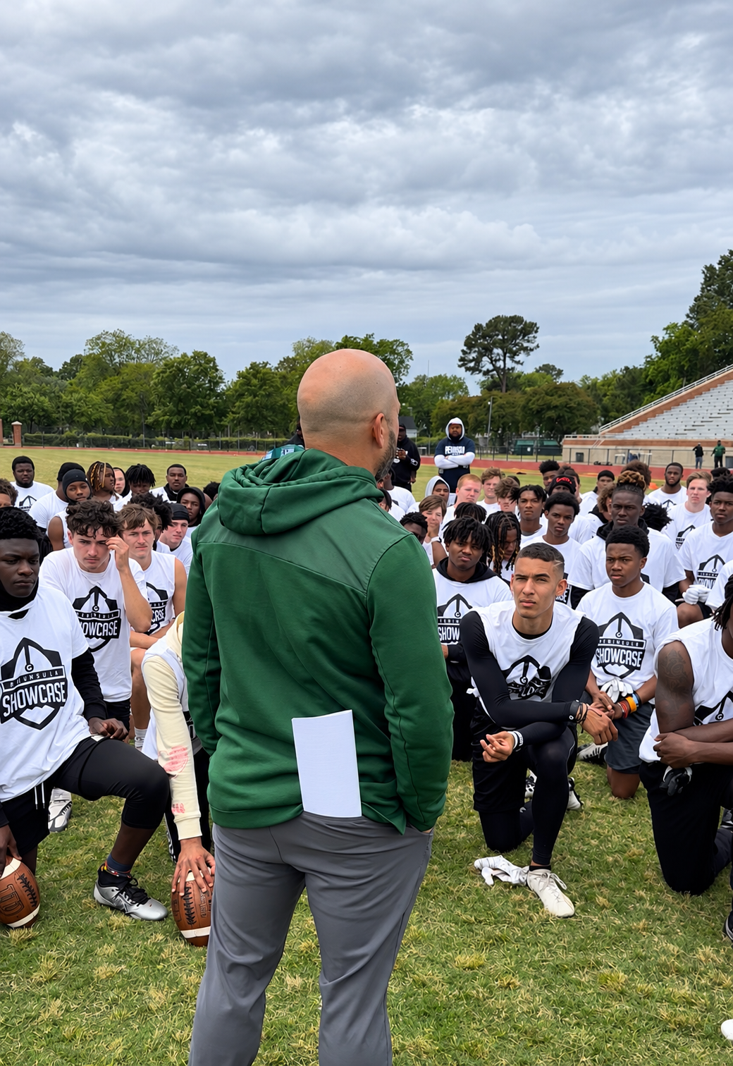A coach speaking to kneeling athletes at the 2023 Peninsula Showcase.