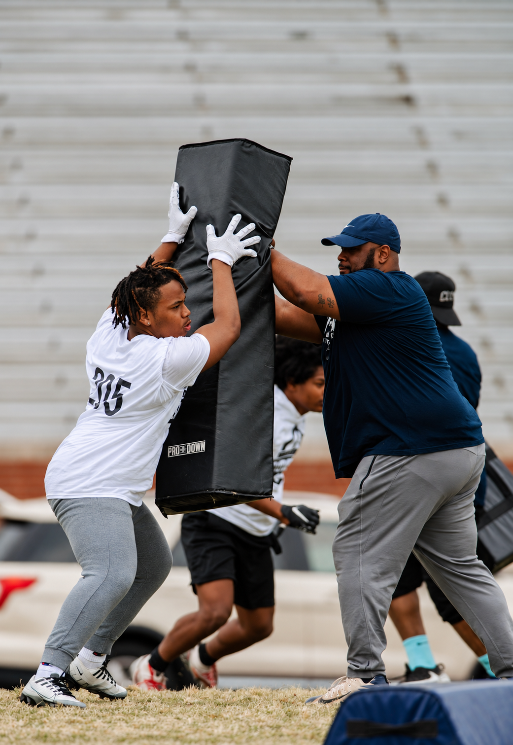 Athletes practicing with blocking pads at the 2023 Peninsula Showcase.