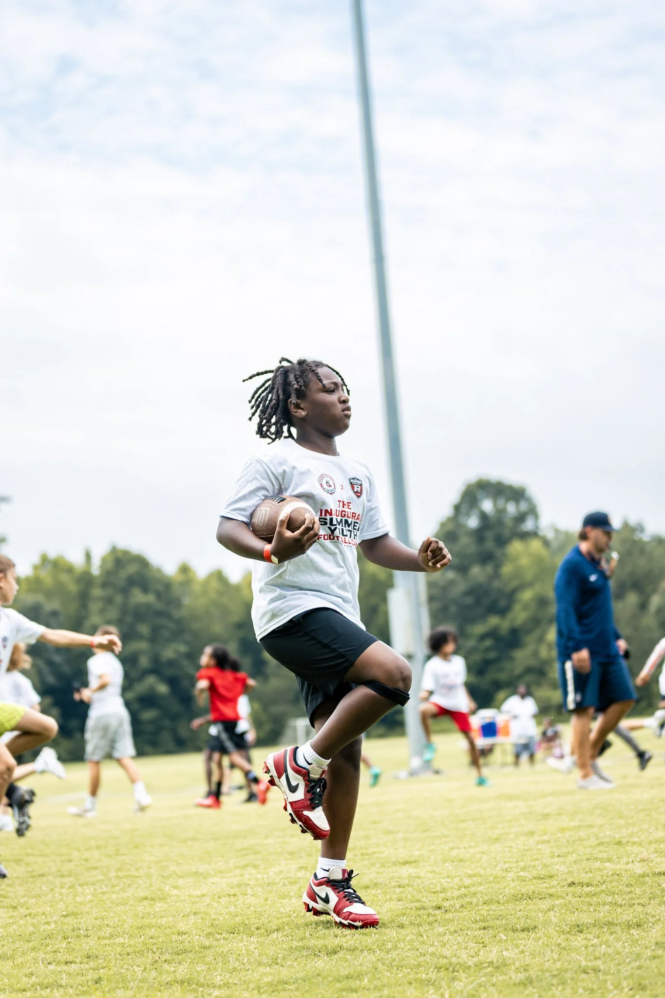 A camper carrying the football during an on-field drill.