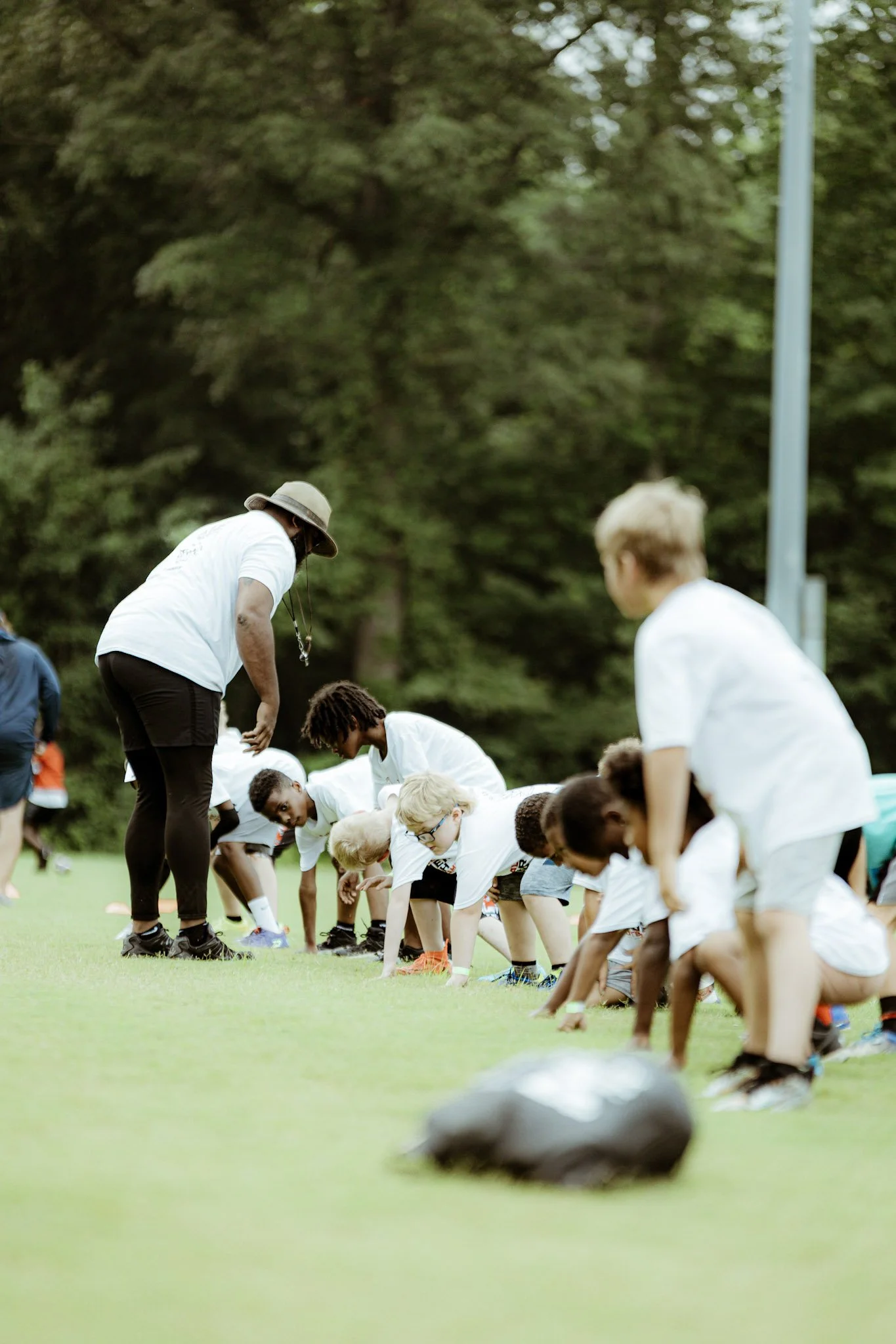 Coaching young athletes through a football drill.
