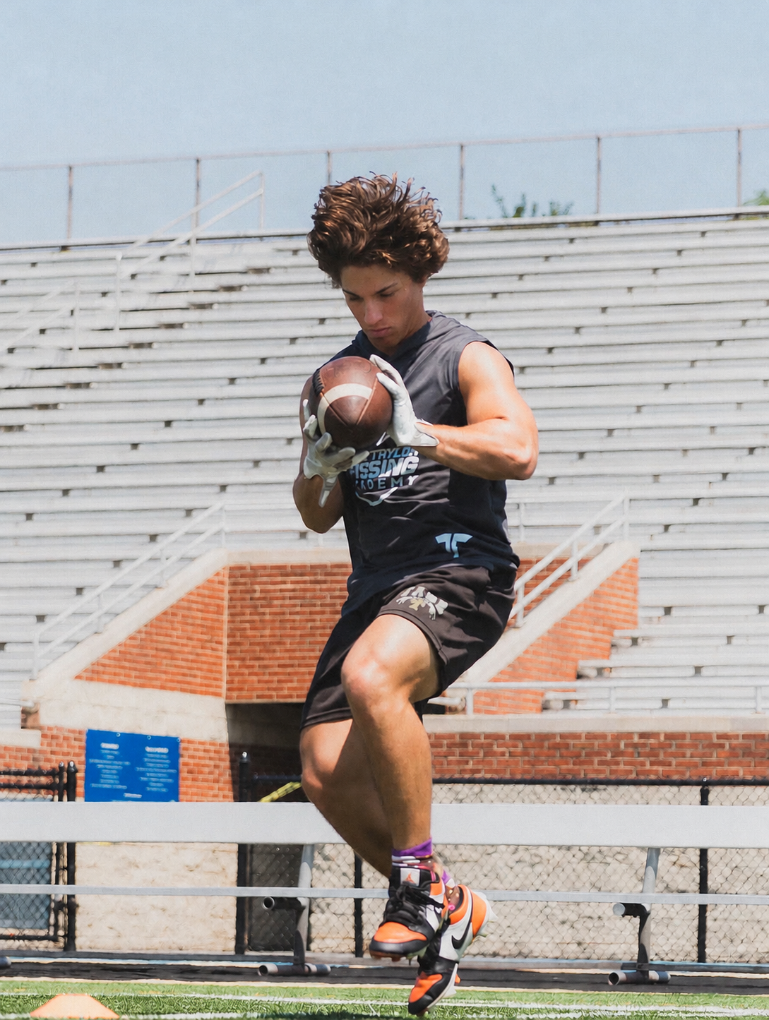 A quarterback working on footwork with the football.
