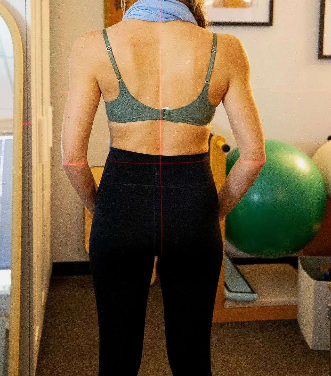 Scoliosis client receiving evaluation with laser technology at BlendFit.