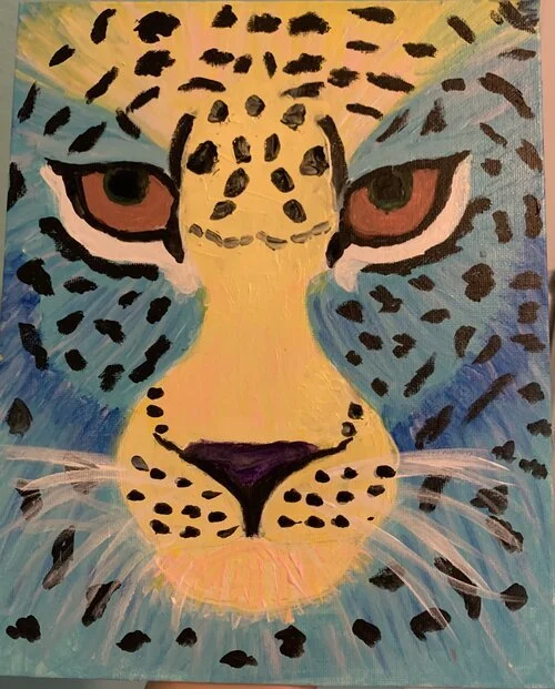 Colorful painting of a leopard's face with yellow, black, blue, and purple hues, highlighting the eyes and facial spots.