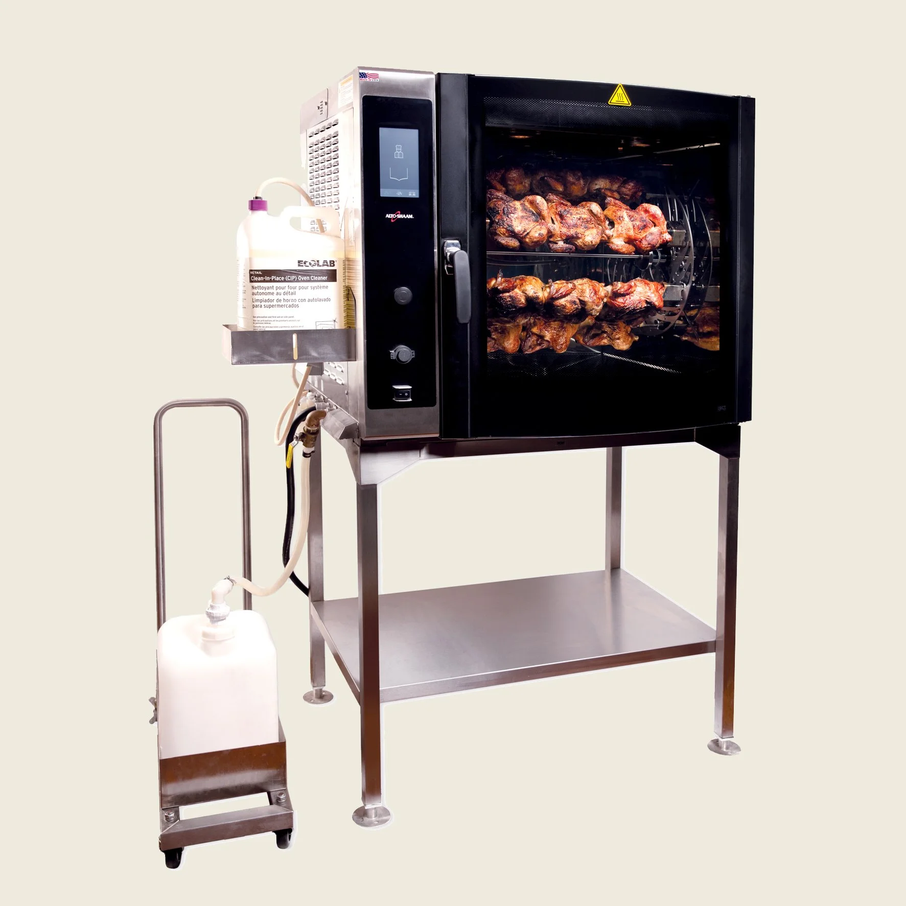 Ein professioneller Rotisserieofen mit rotierenden Hähnchen. An der Seite hängt eine Reinigungsflasche für den Ofen und ein Tank für Wasser oder Reinigungsmittel auf Rollen.