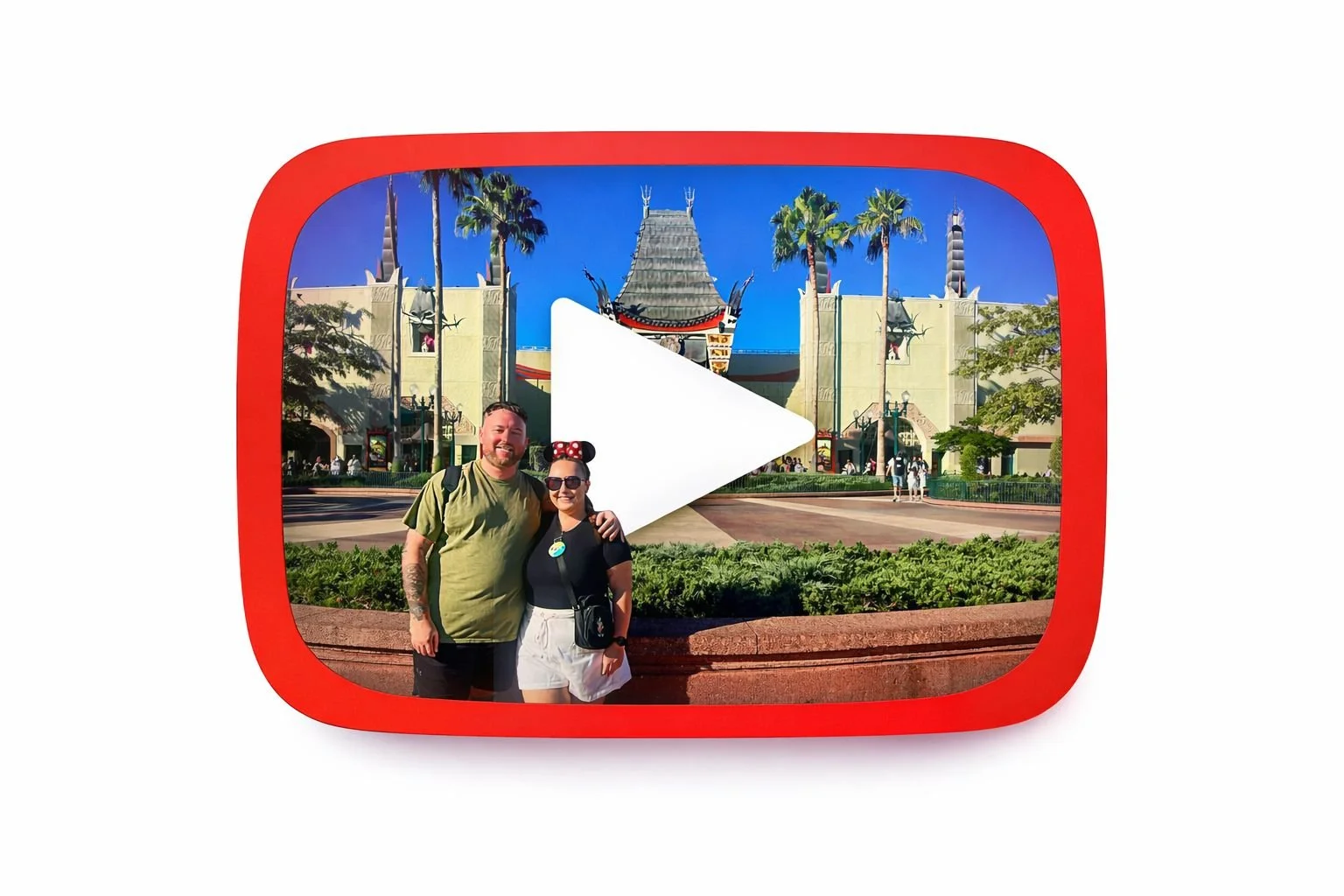 A YouTube-like icon with a photo inside of a couple posing in front of the Muppet*Vision 3D attraction at Disney's Hollywood Studios, with a large play button overlay.