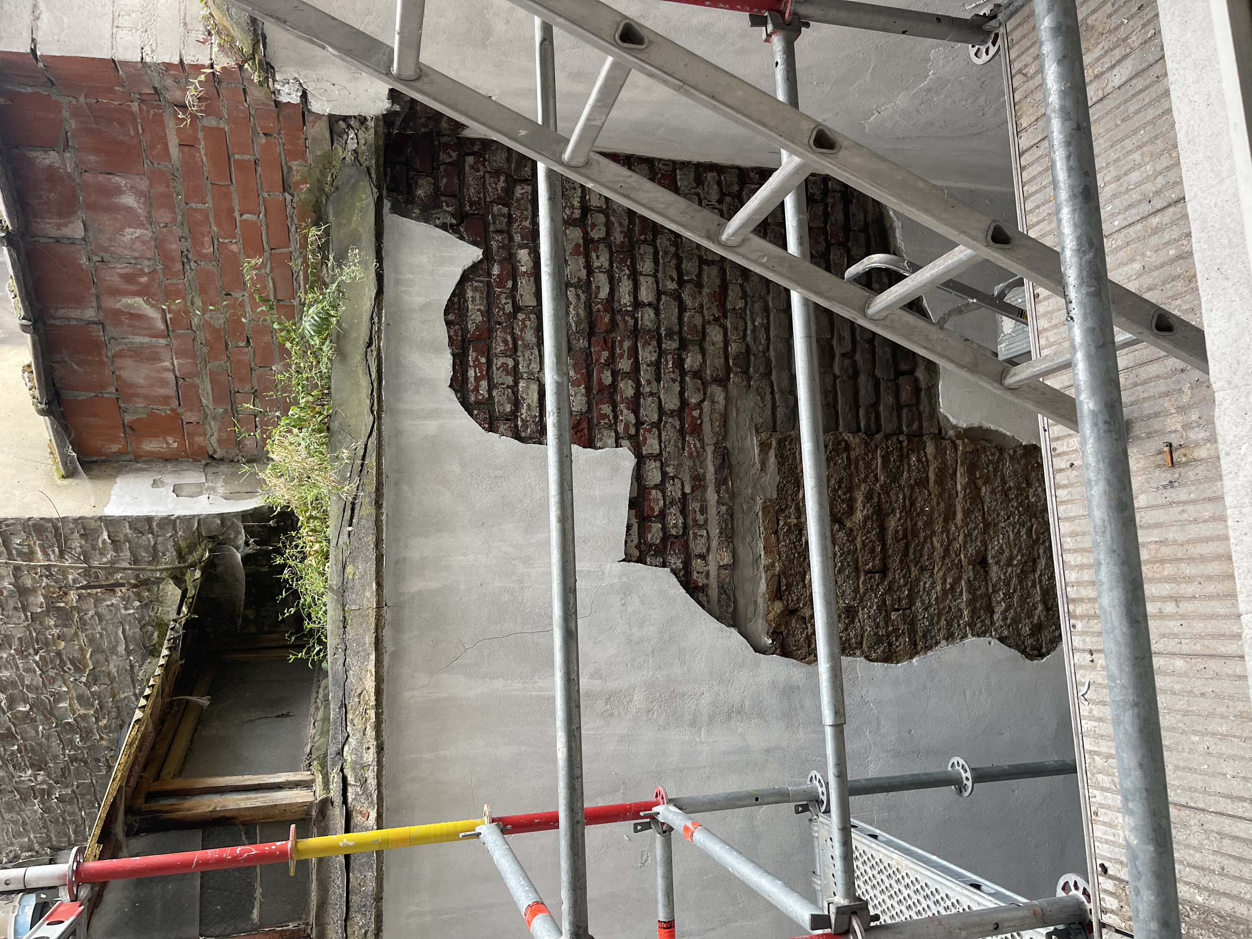 een gevelmuur waar een deel bakstenen zichtbaar zijn