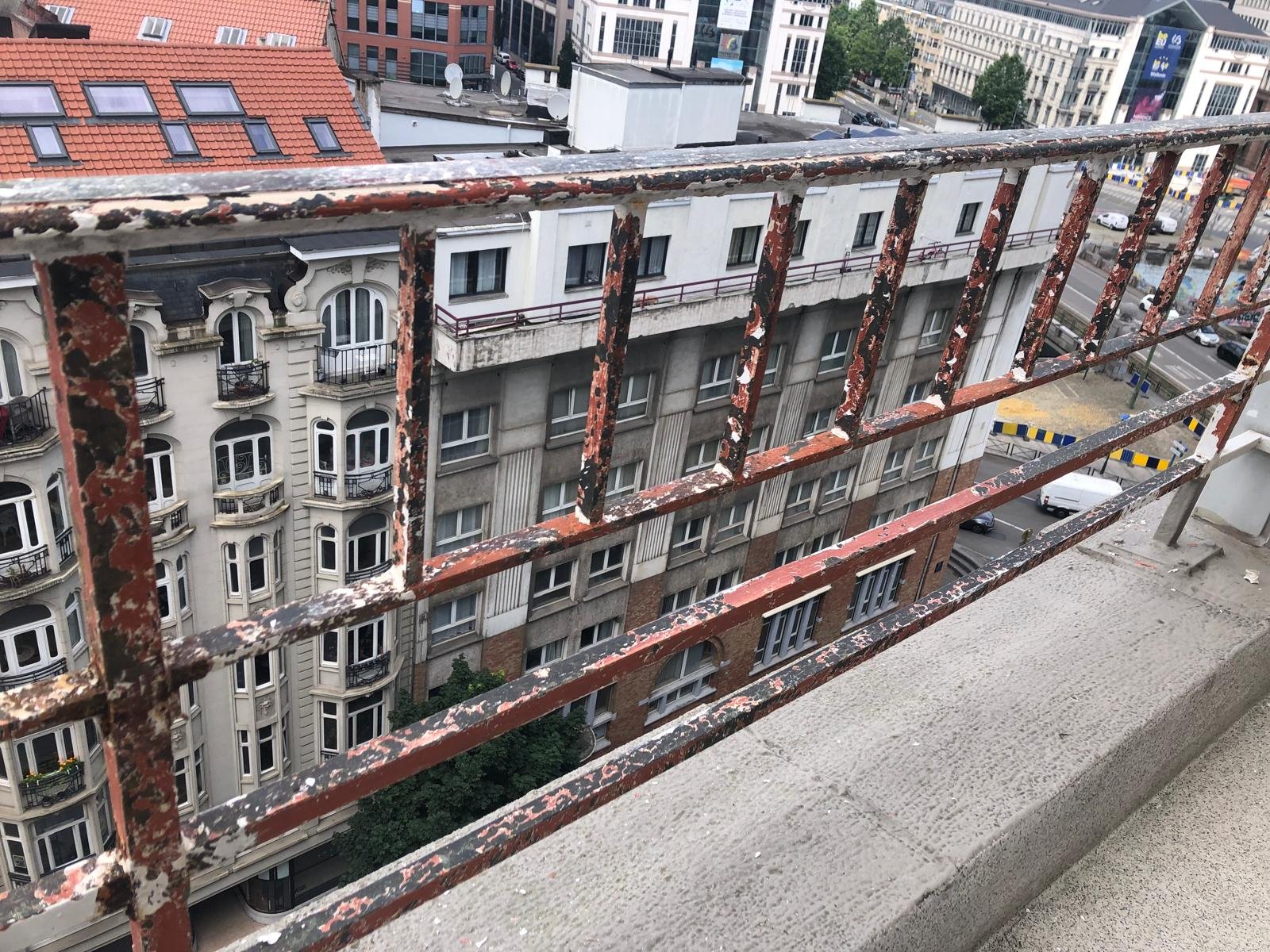metalen omheining op een balkon in Brussel waarvan de verf werd afgehaald voor het her-schilderen 