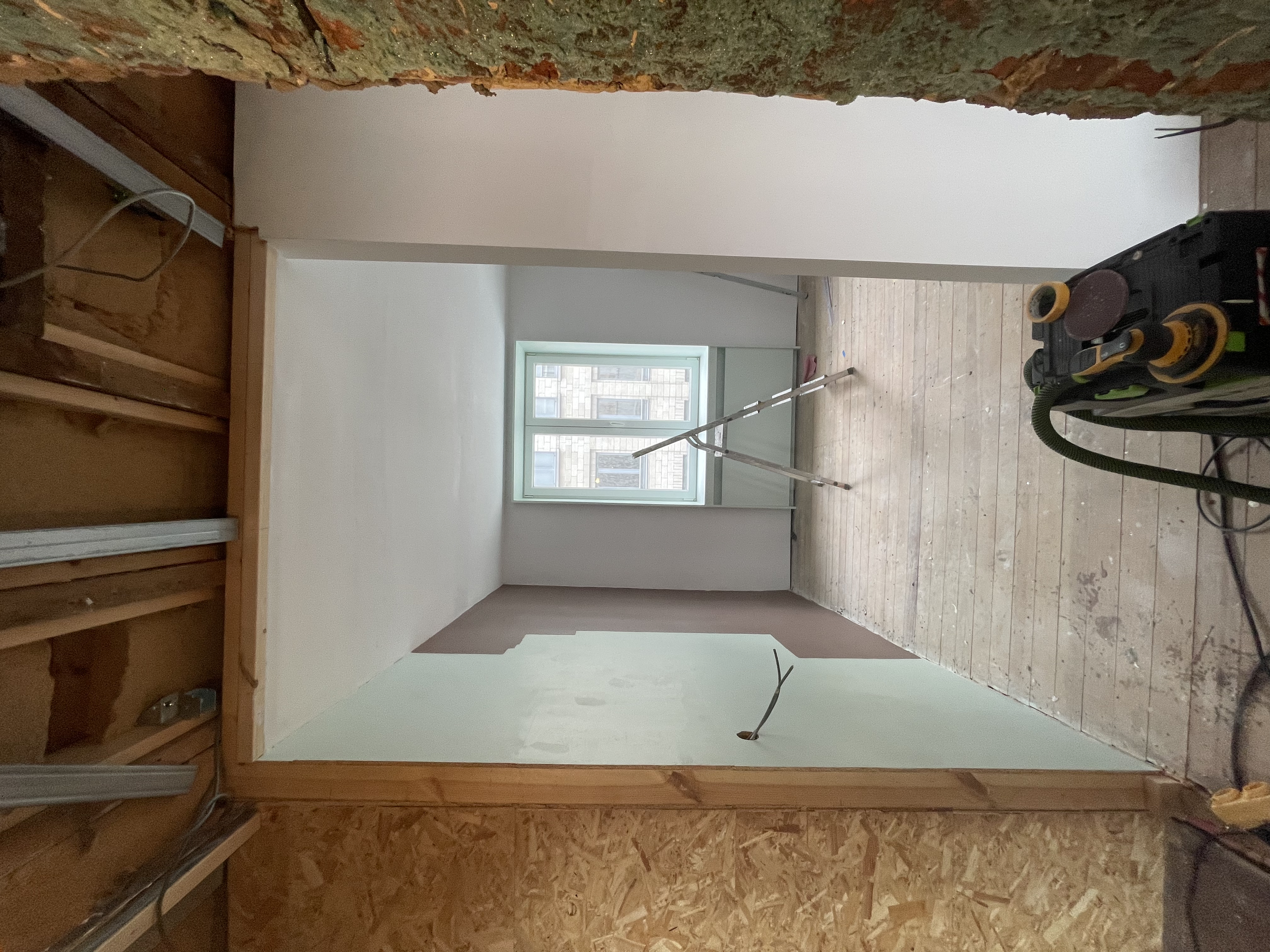 de kamer is aan één kant geschilderd met twee verschillende kleuren. Het plafond en de rest van de muren zijn in een paars-wit kleur geschilderd. 