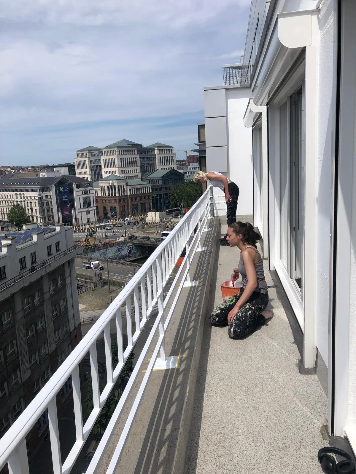 De schilders die de omheining schilderen in het wit