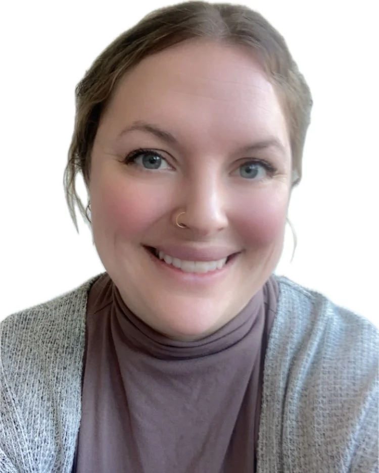 A woman with light skin, blue eyes, short brown hair, wearing a nose ring, a mauve turtleneck, and a light gray cardigan, smiling at the camera.