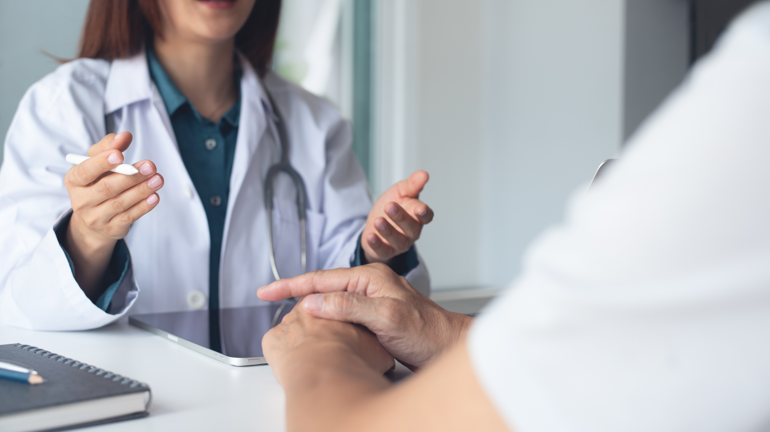 Provider sitting at a desk talking to a patient