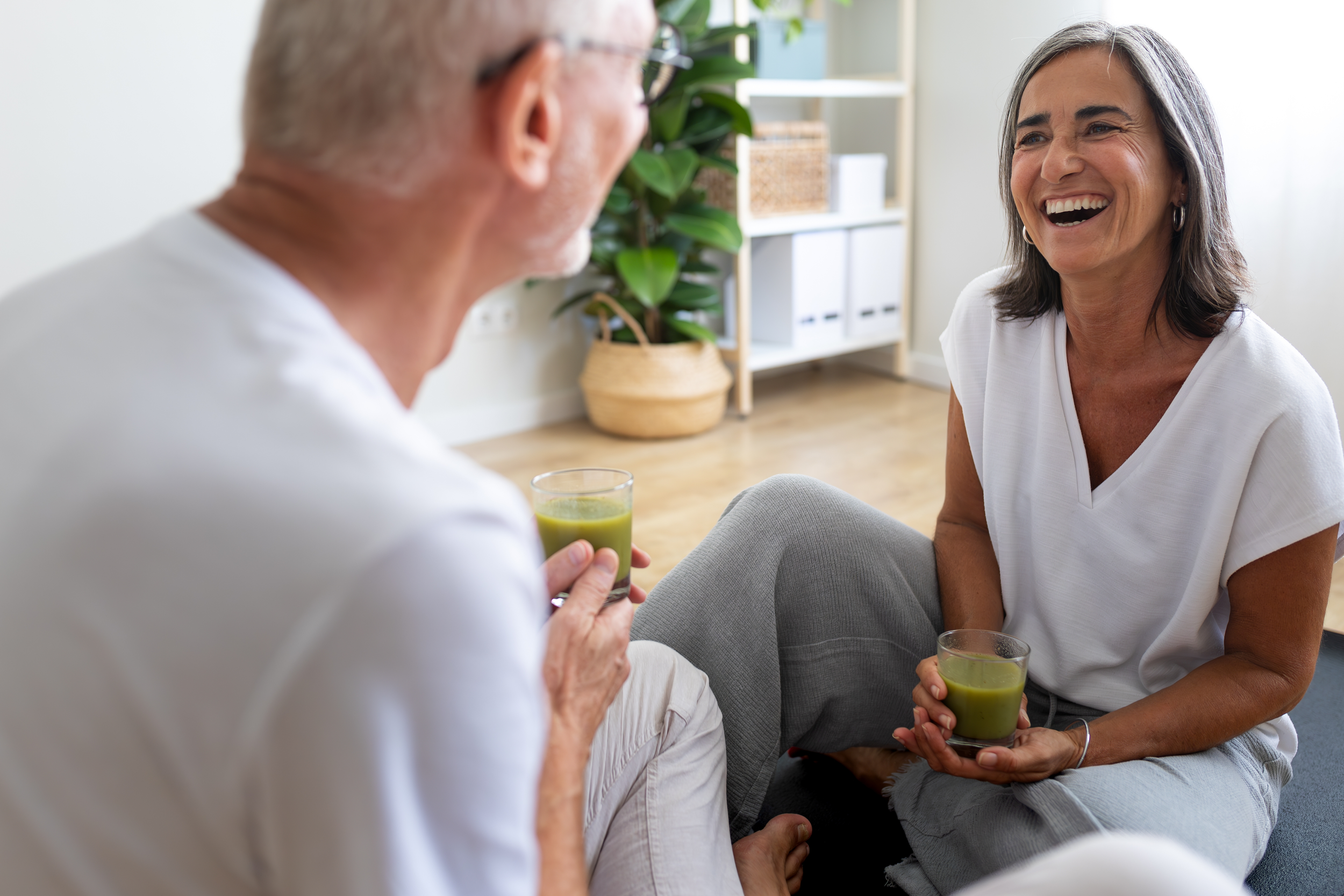 Woman and man sitting with green drinks in their hands