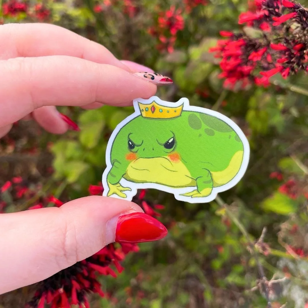 rain frog with a crown that looks grumpy and is blushing