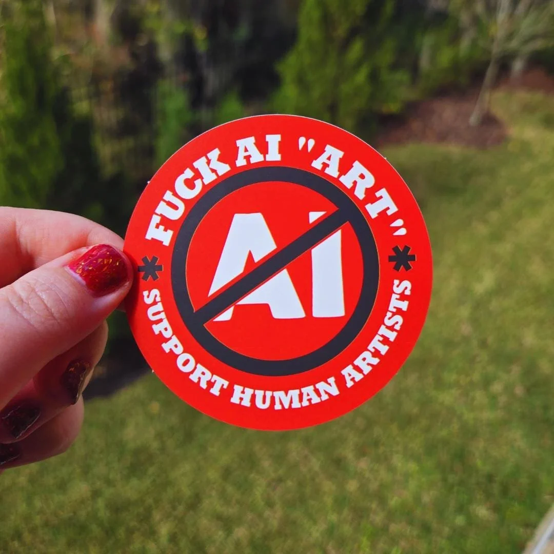 red, black, and white sticker that says fuck AI art on top with the middle crossing out AI and the bottom says support human artists