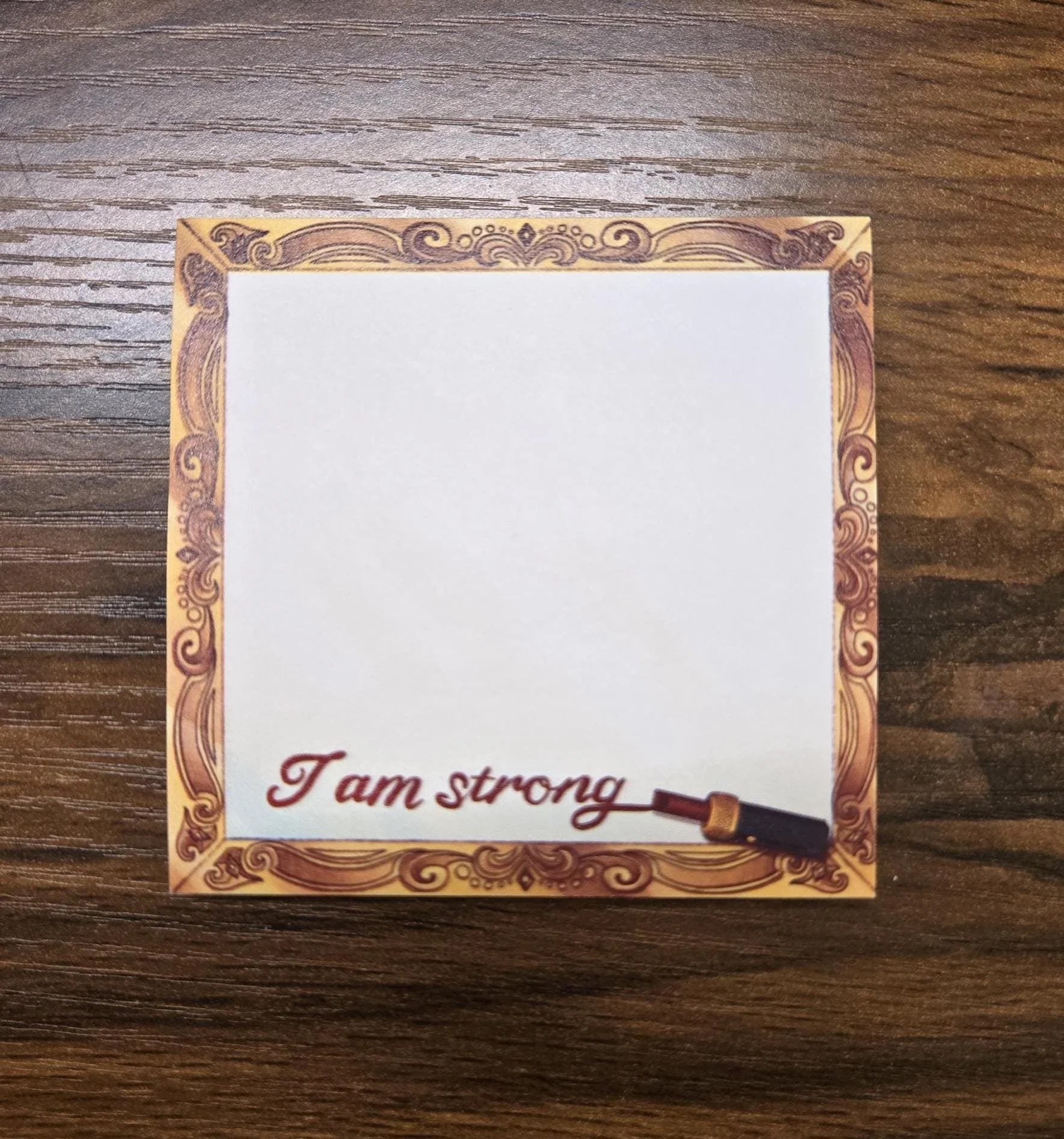 sticky note with a flourish frame boarder with the lipstick writing I am strong at the bottom