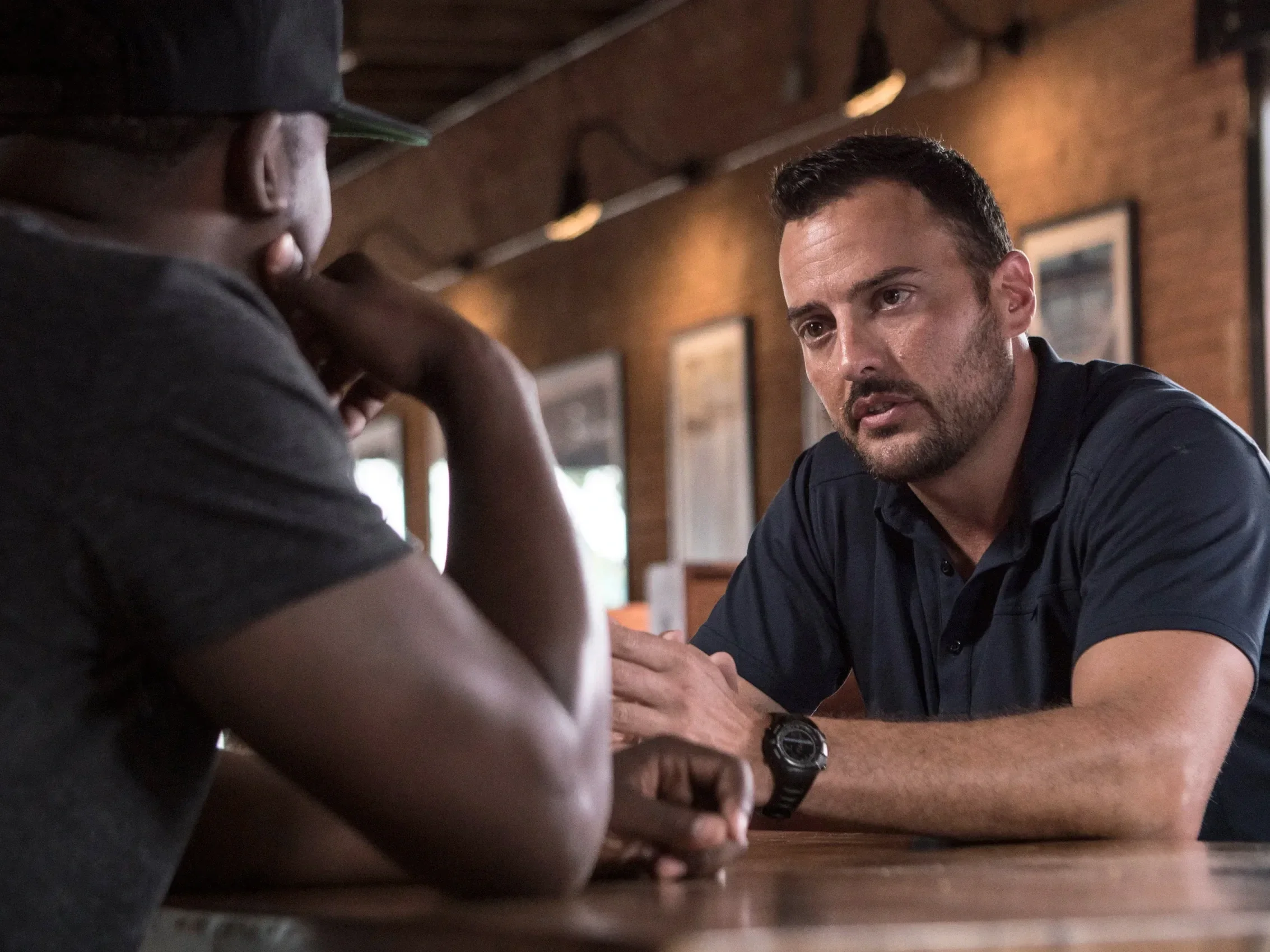 Corporate lifestyle photo of two professionals in a focused business discussion, photographed to showcase leadership communication and workplace culture.