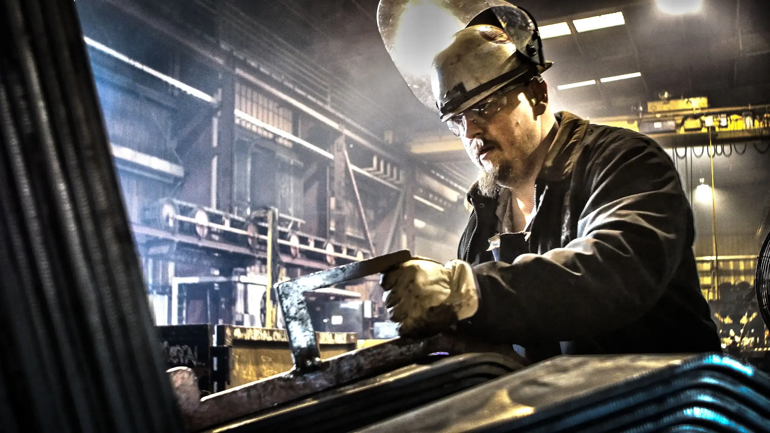 Worker fabricating railcar part in a Texas metal fabrication shop.