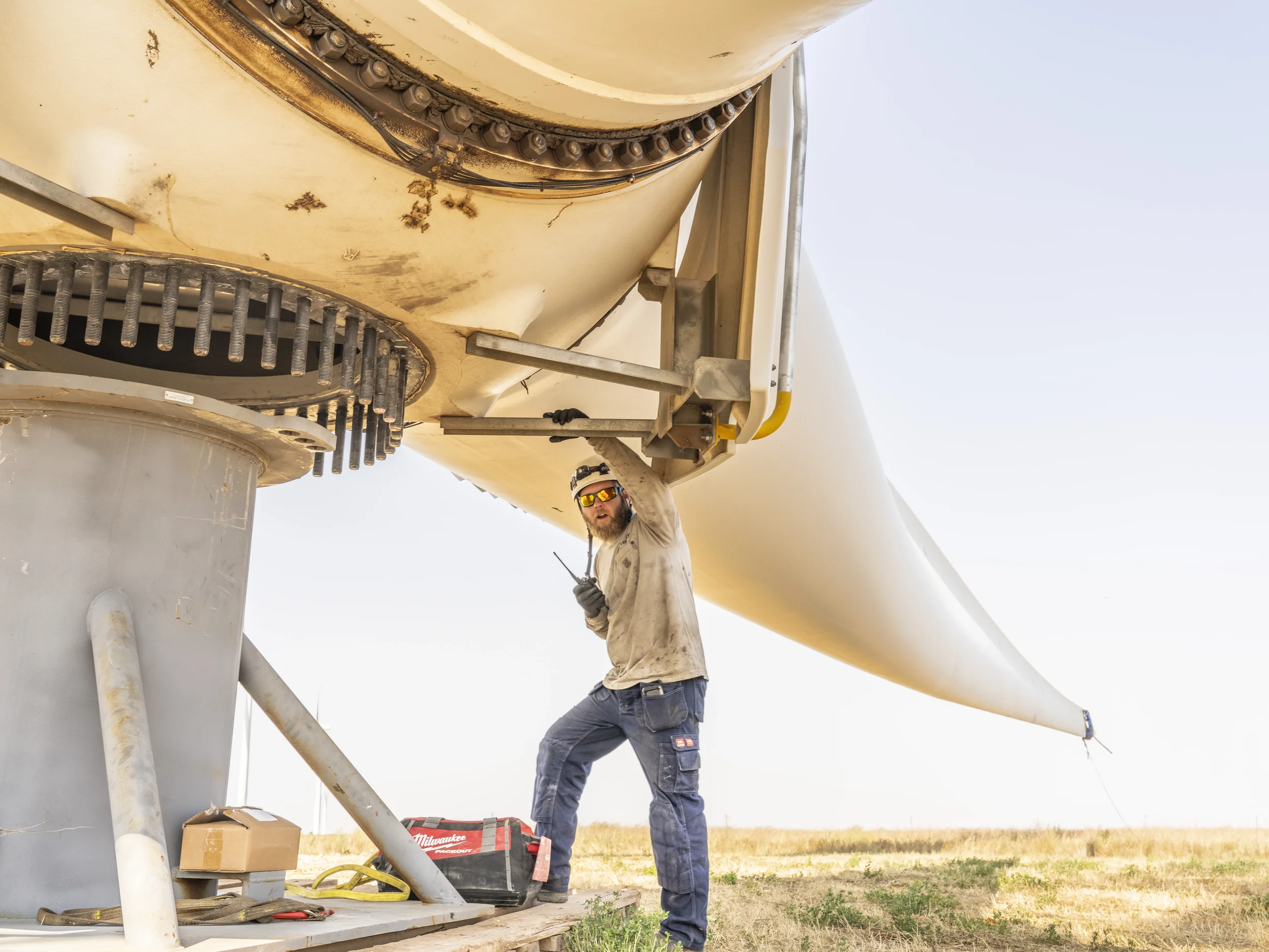 Energy infrastructure technician performs mechanical verification on a large-scale wind power component, supporting safe installation, renewable energy operations, and long-term system performance.