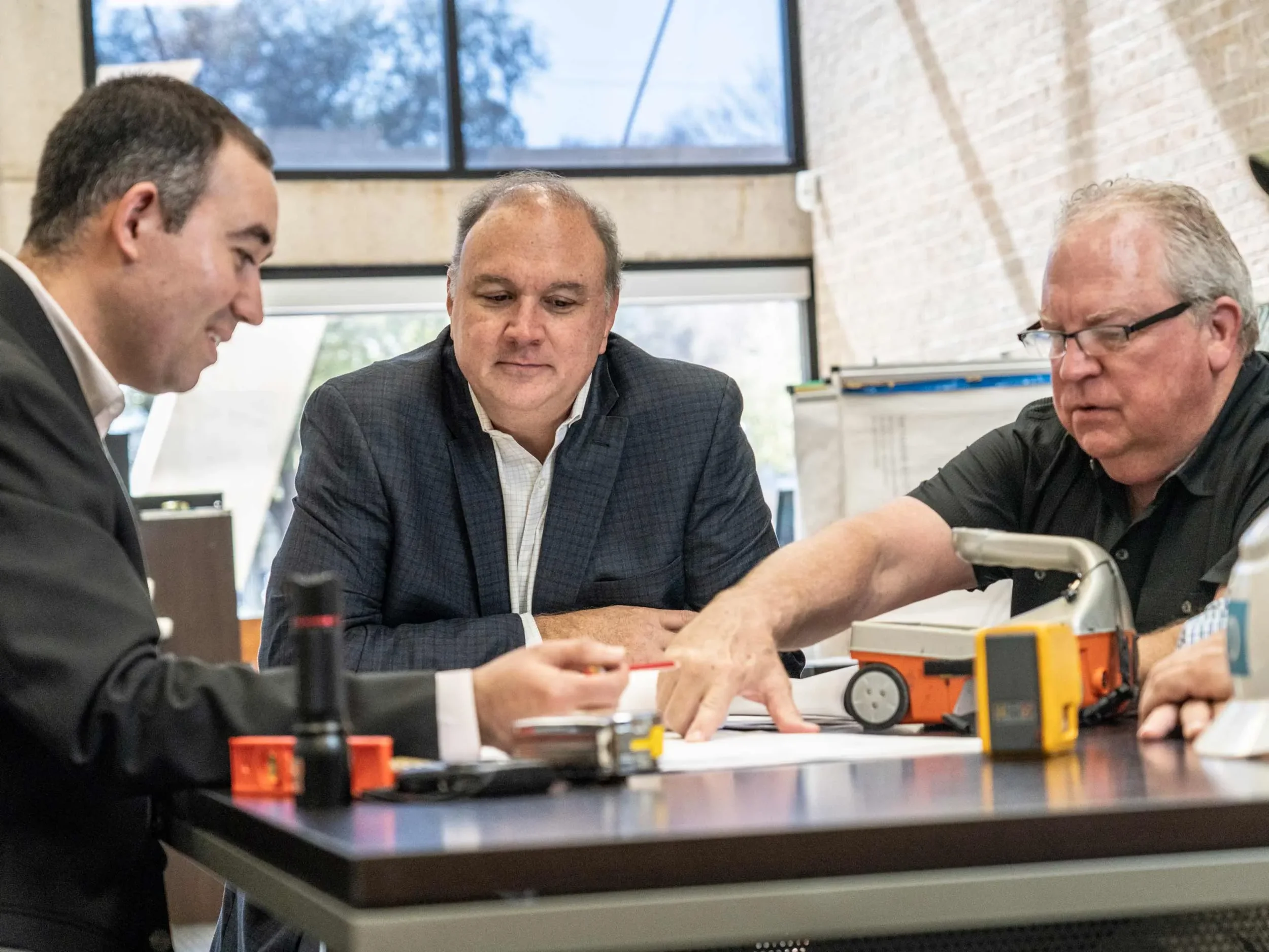 Corporate lifestyle image of executive leadership collaborating during a working session. Reinforces strategic thinking, experience, and professional decision-making.