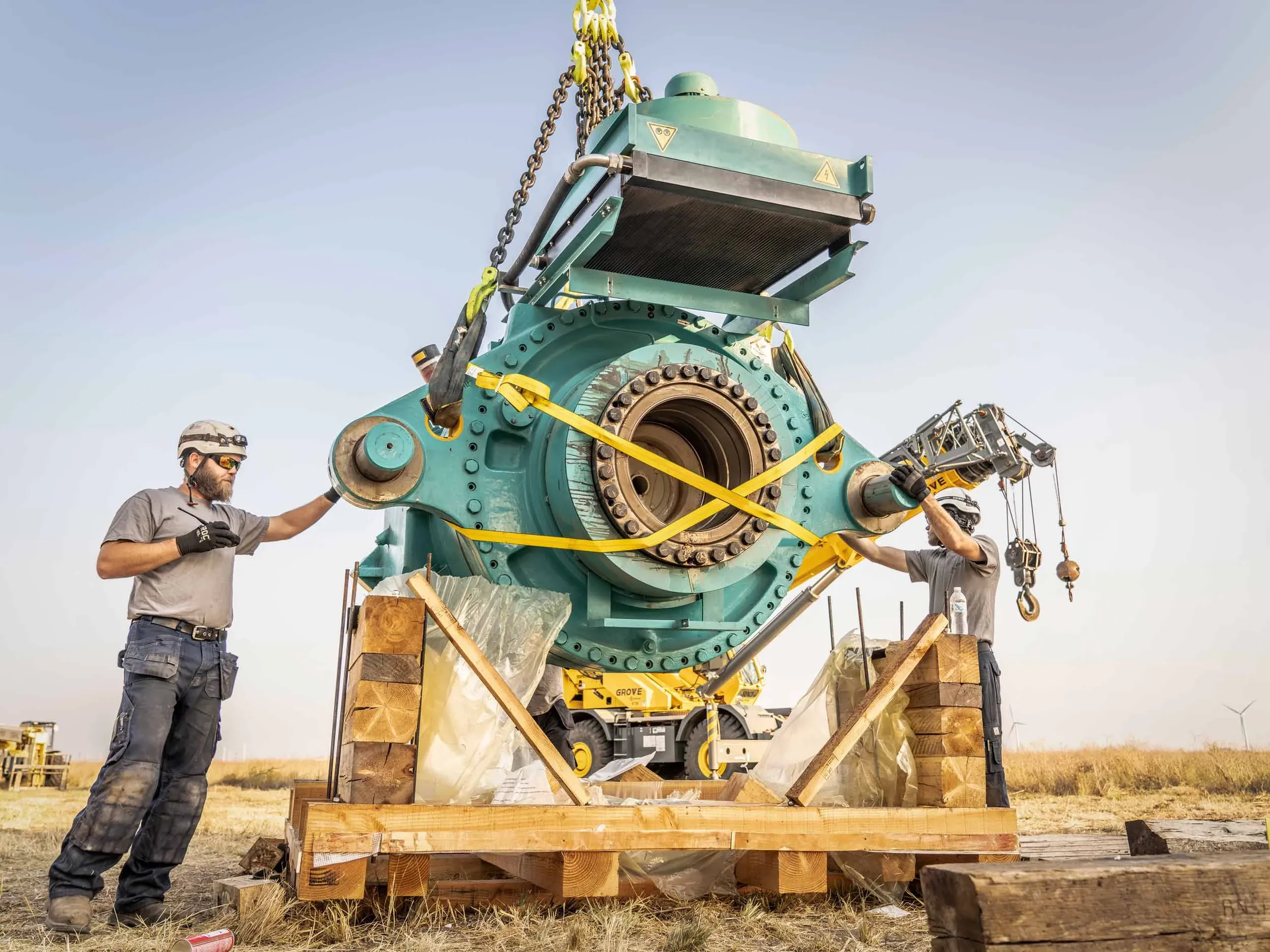 Field maintenance crew member verifies alignment of a large mechanical assembly during outdoor equipment installation, demonstrating precision handling, mechanical integration, and on-site industrial maintenance.