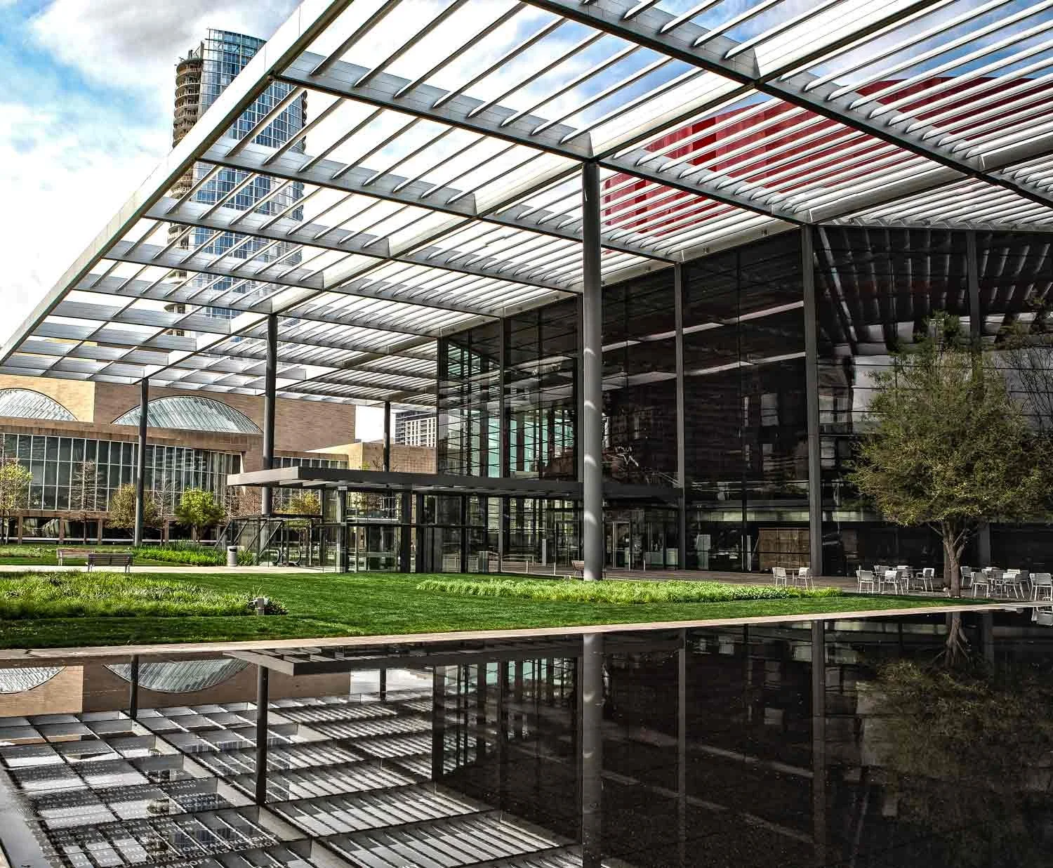 Professional architectural photography of the Winspear Opera House exterior in the Dallas Arts District, featuring the iconic red glass facade and solar canopy by C Ray Pictures.