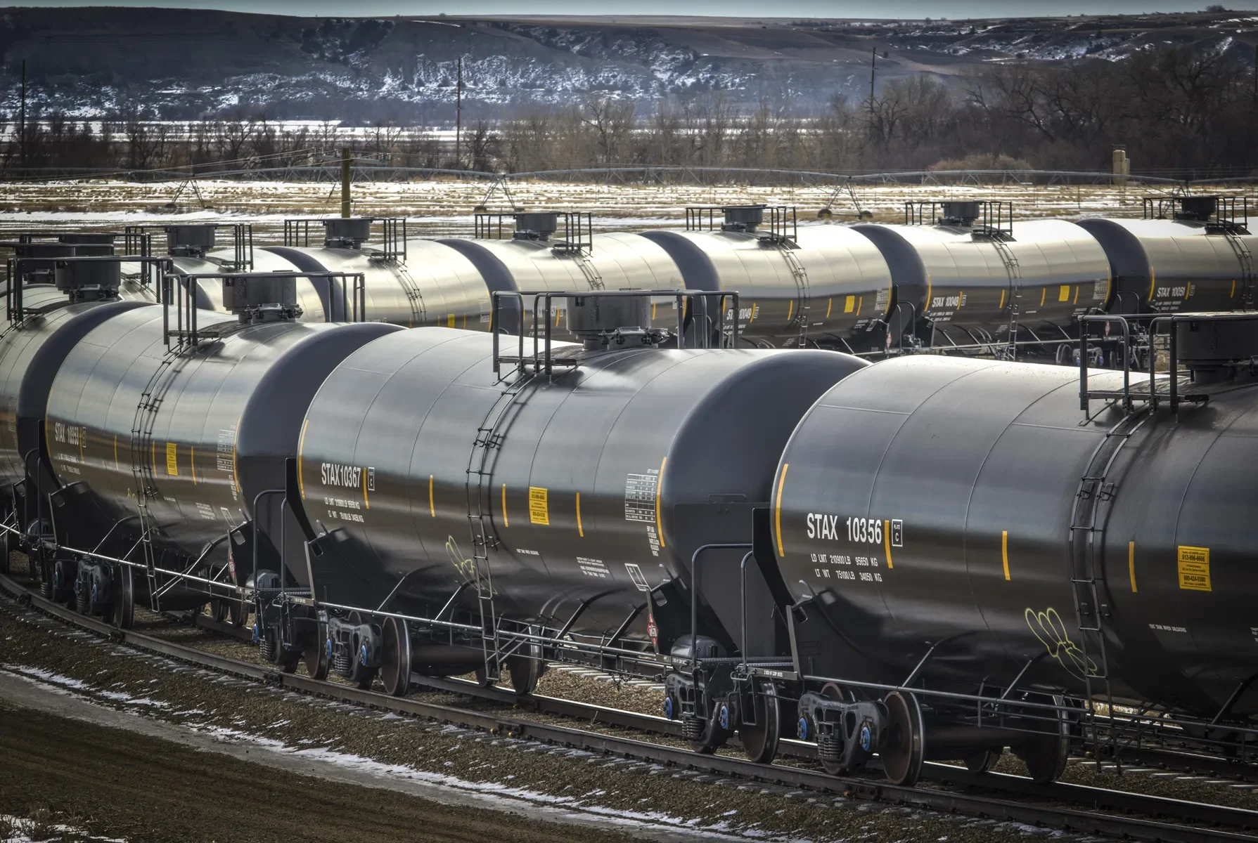Dallas industrial photography of a long line of rail tanker cars on active tracks, illustrating large-scale transportation infrastructure, logistics operations, and the industrial rail industry.