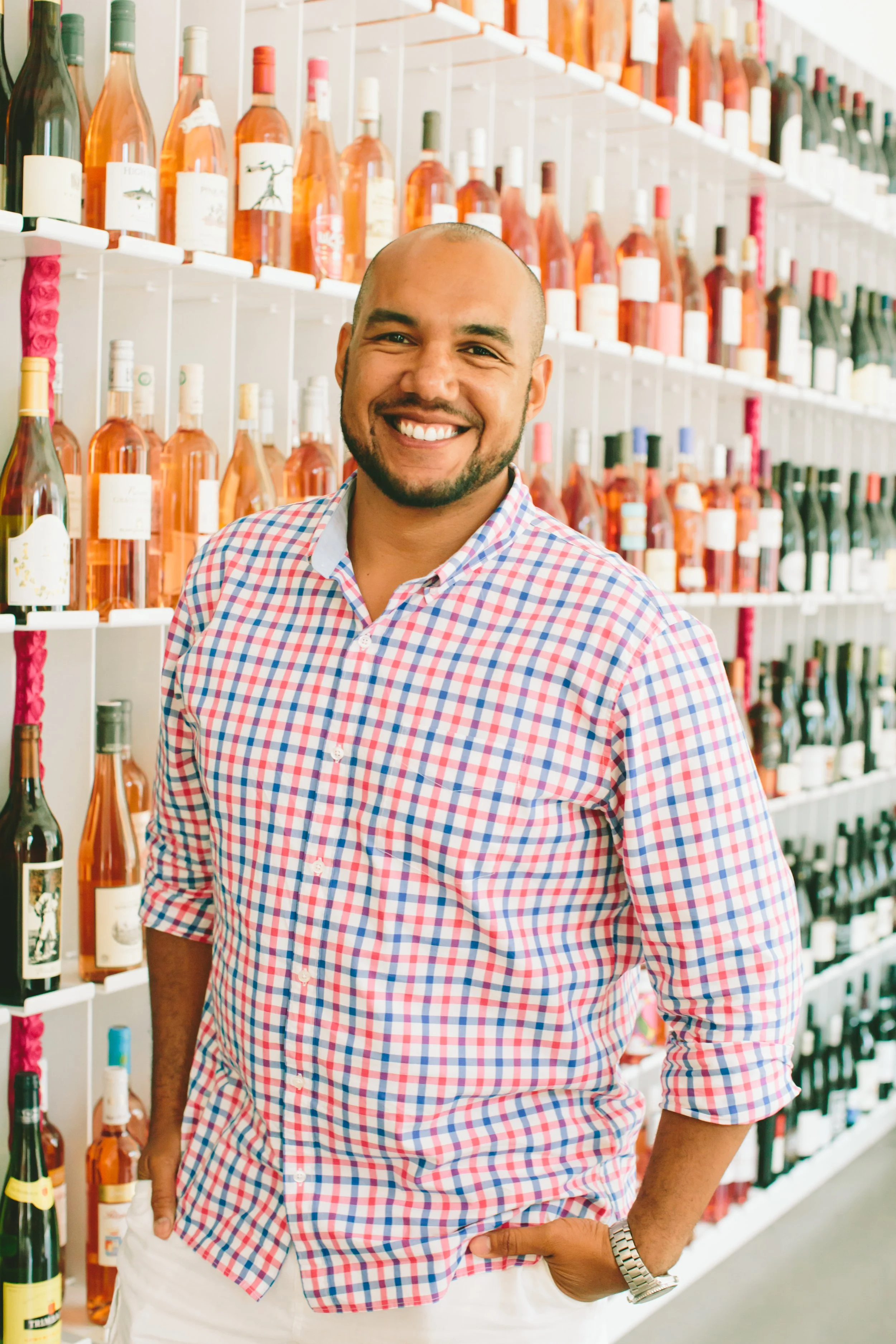 TJ Douglas, Boston's best wine tasting events, stands in front of a wall of wine in Boston