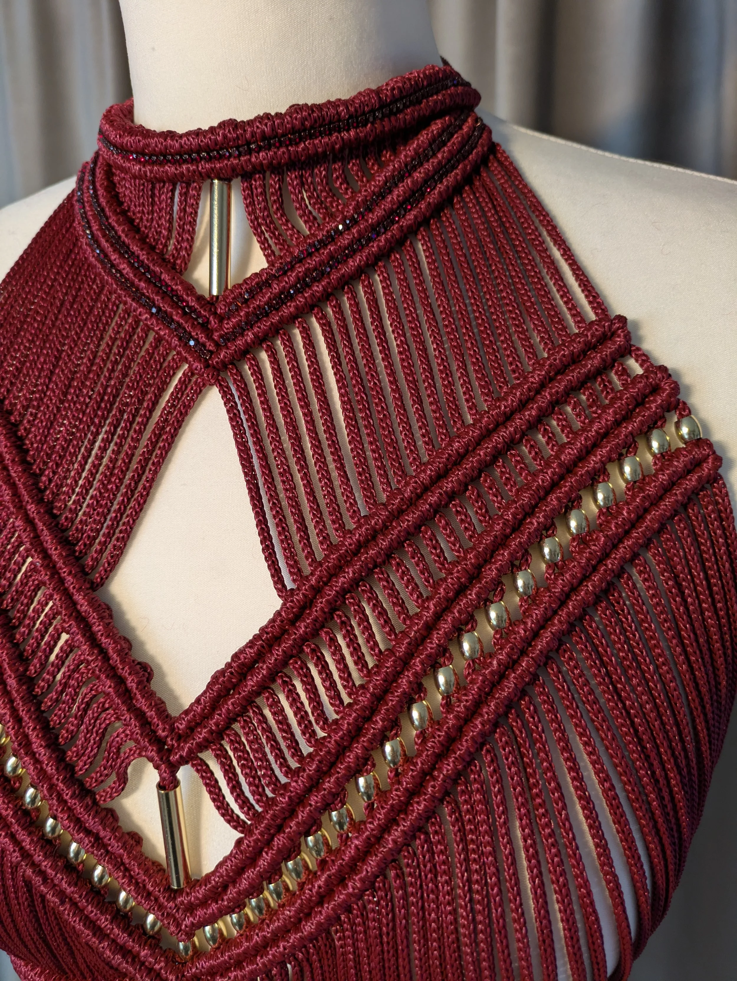 Nahaufnahme der Makramee-Knüpftechnik mit aufgenähten Strasssteinen auf hochwertigem Polyestergarn