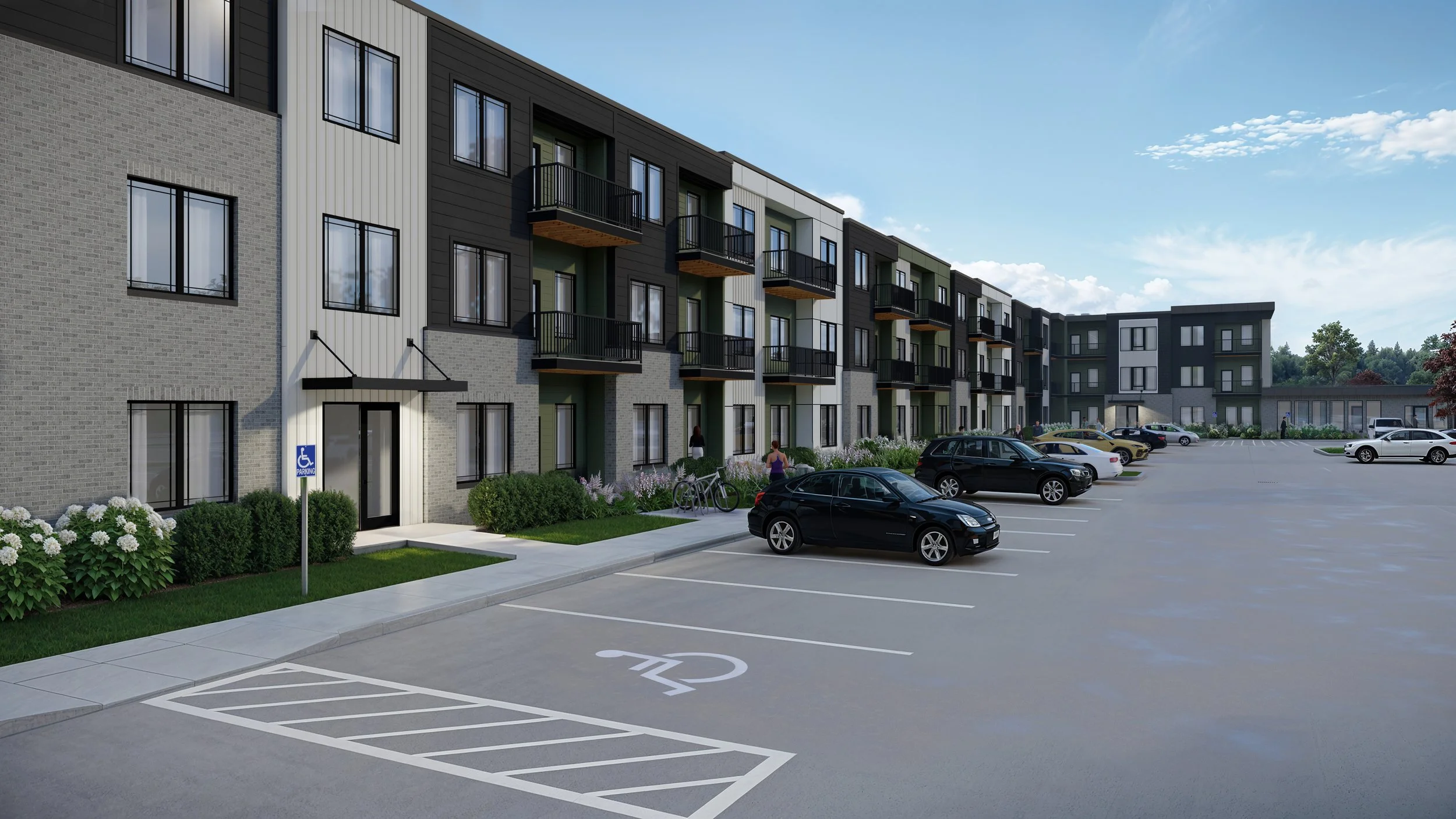 A modern multi-story apartment complex with a parking lot in front. The parking lot includes spaces for handicapped parking. There are several cars parked, and a few people are near the entrance, with some bicycles visible.