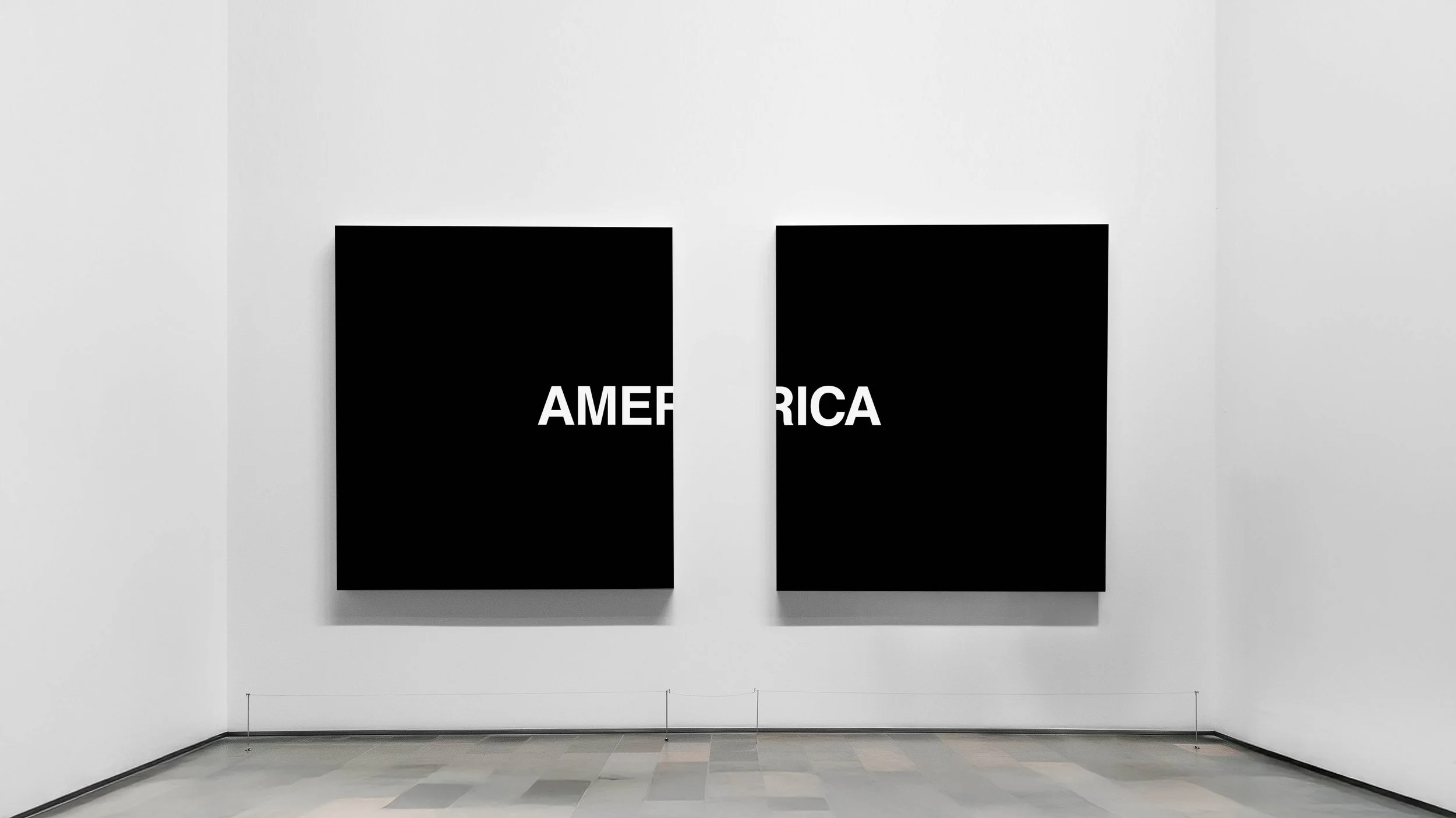Two black square art pieces on a white gallery wall, each with white text; the left one partially visible displays 'AMER', the right one has 'ICA' visible, likely forming the word 'AMERICA'.