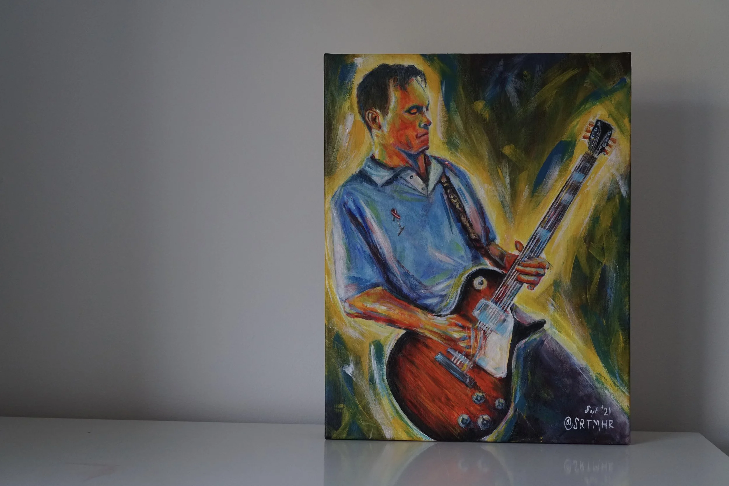 Colorful painting of a man playing an electric guitar, with vivid brushstrokes and abstract background.