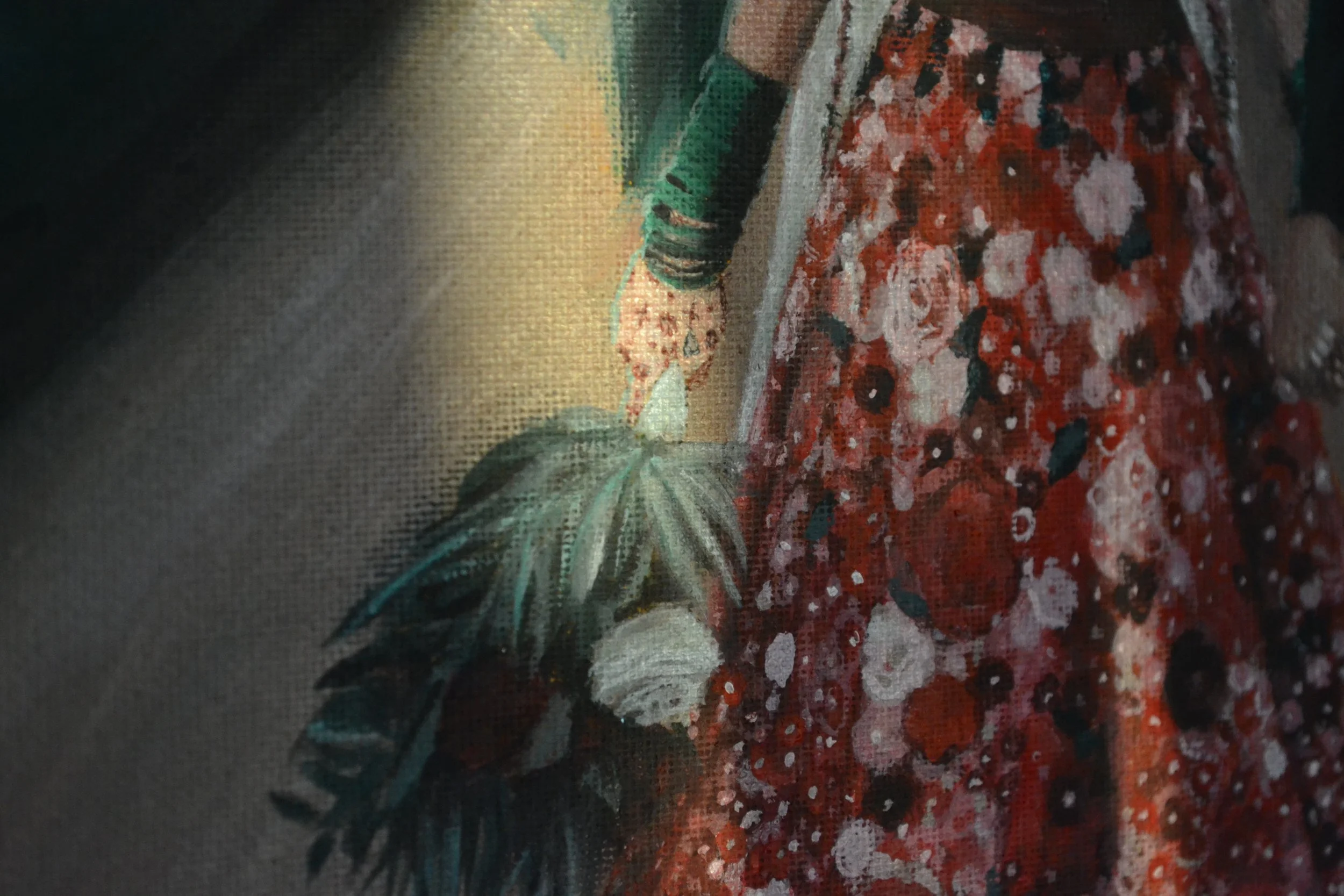 A person in a black jacket and a long red floral dress holding a bouquet of flowers.