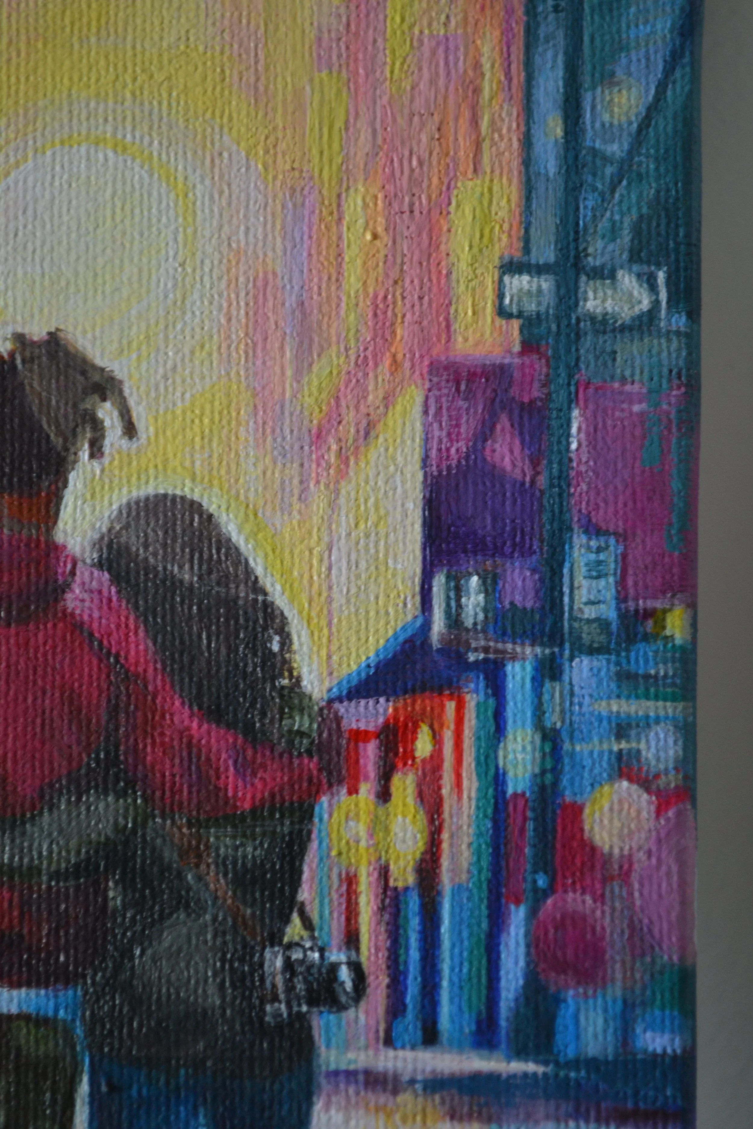 Close-up of a colorful abstract painting featuring a person sitting with their back turned, surrounded by vibrant geometric shapes and bright colors.