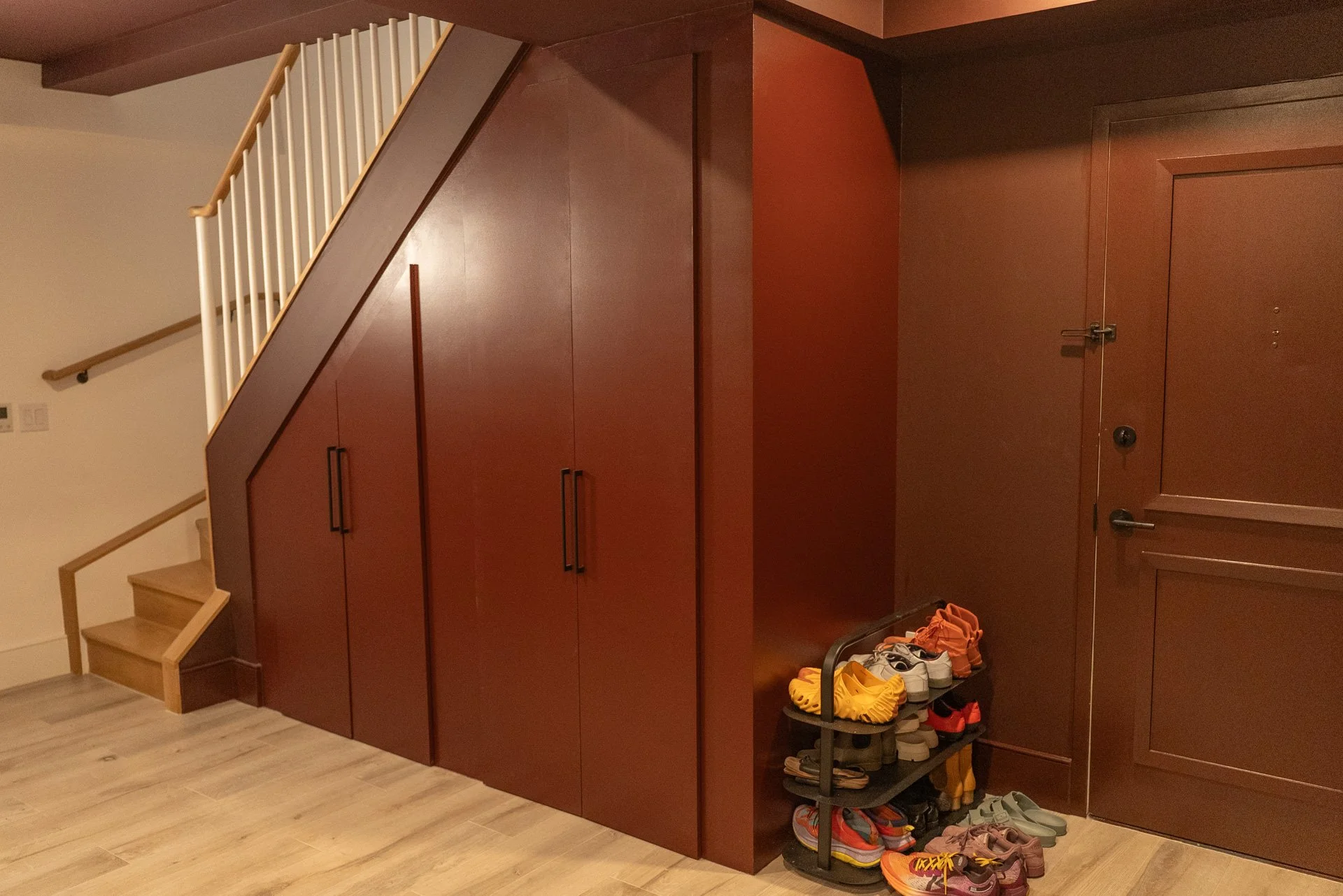 Under stairwell partition, Brooklyn, NY. Baltic birch plywood, soft close doors, black bar handles.