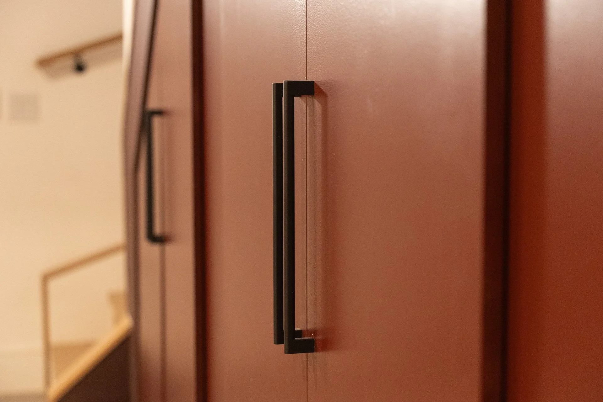 Under stairwell partition, Brooklyn, NY. Baltic birch plywood, soft close doors, black bar handles.