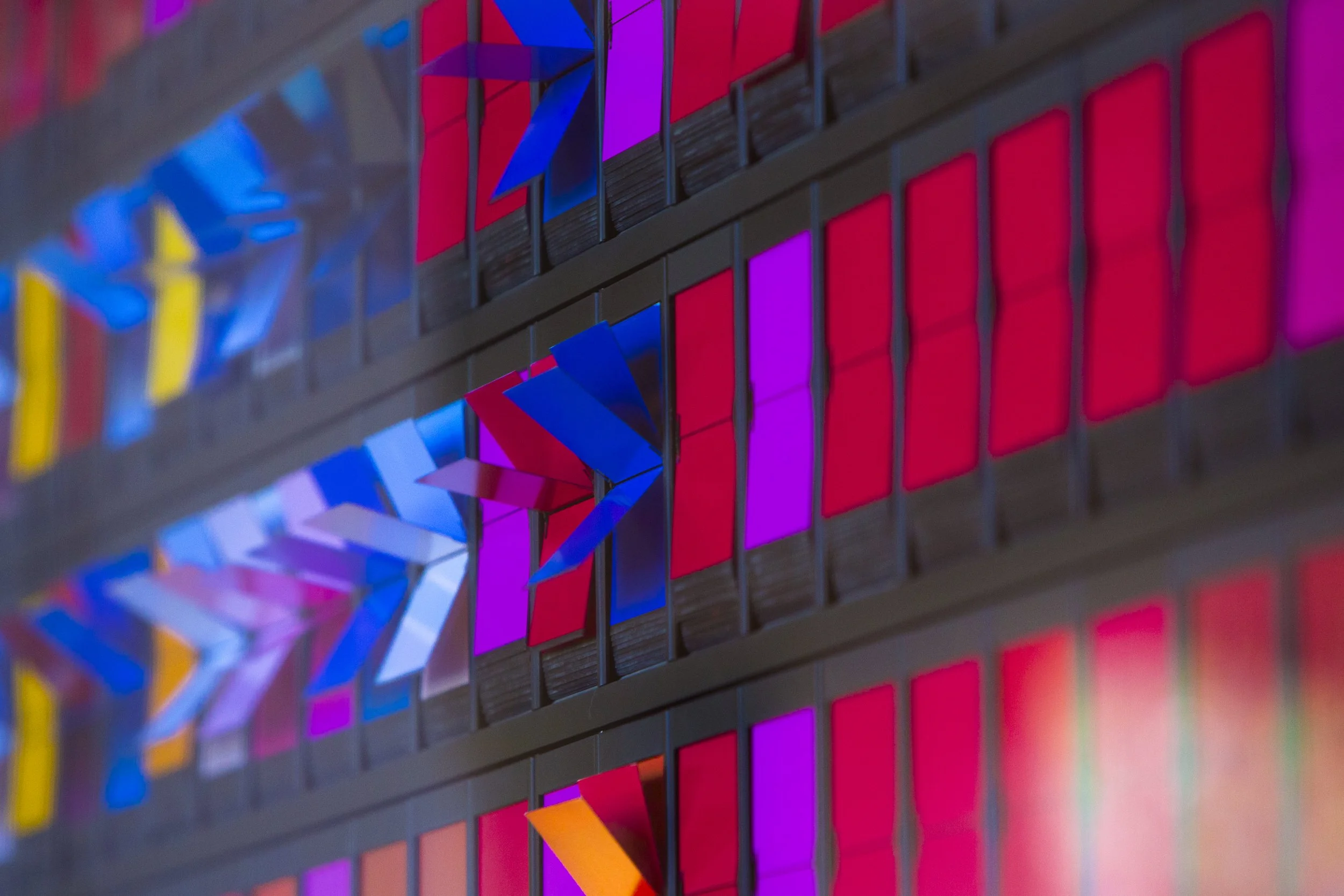 Close-up one of two "Change Walls" located at Knight Management Center. "Monument to Change as It Changes" kinetic art installation by artist Peter Wegner with bright red, orange, and yellow colors.