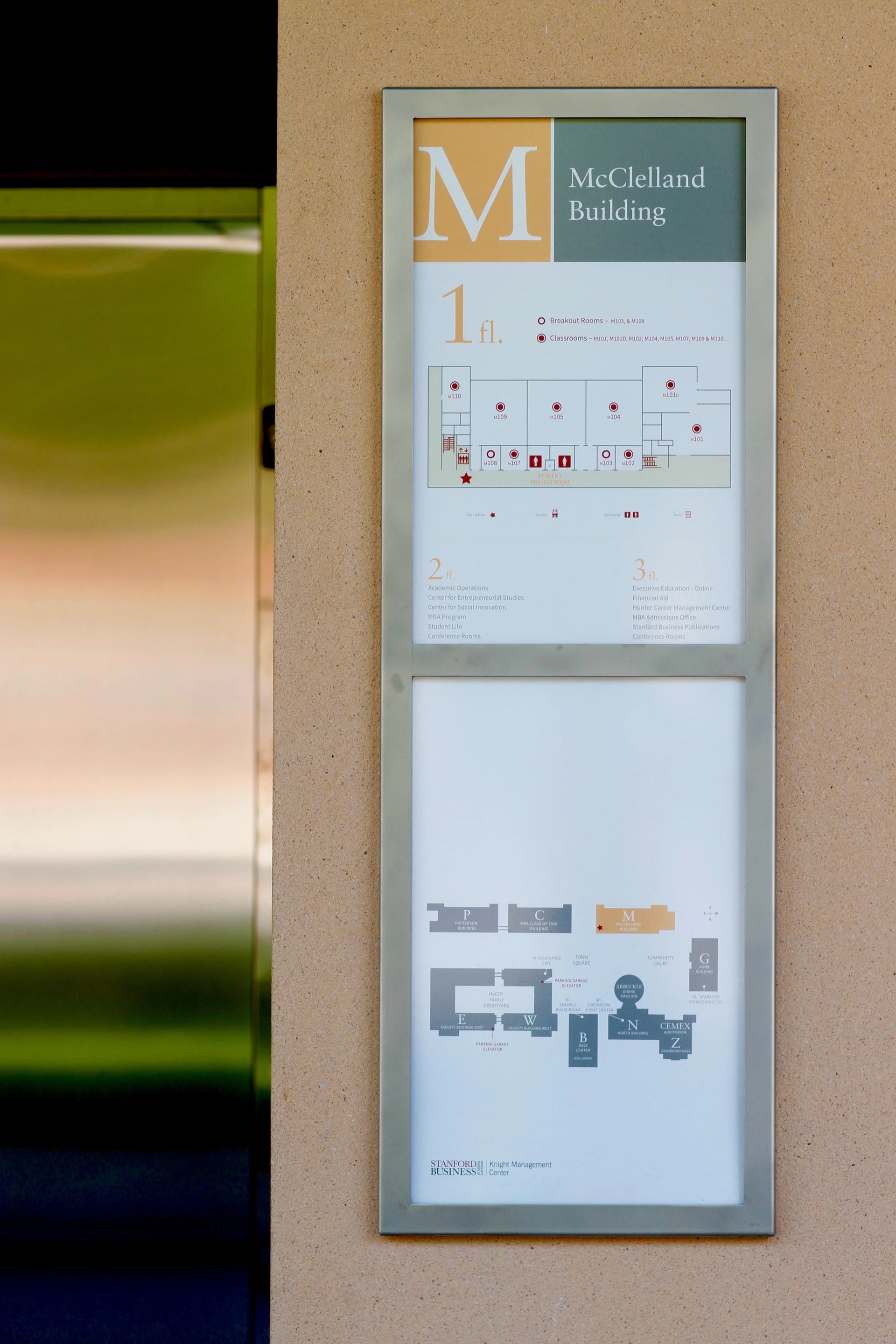 Custom wayfinding and environmental graphics at Stanford Graduate School of Business: Building directory sign for McClelland Building, showing floor plans for the 1st, 2nd, and 3rd floors including room labels and functions.